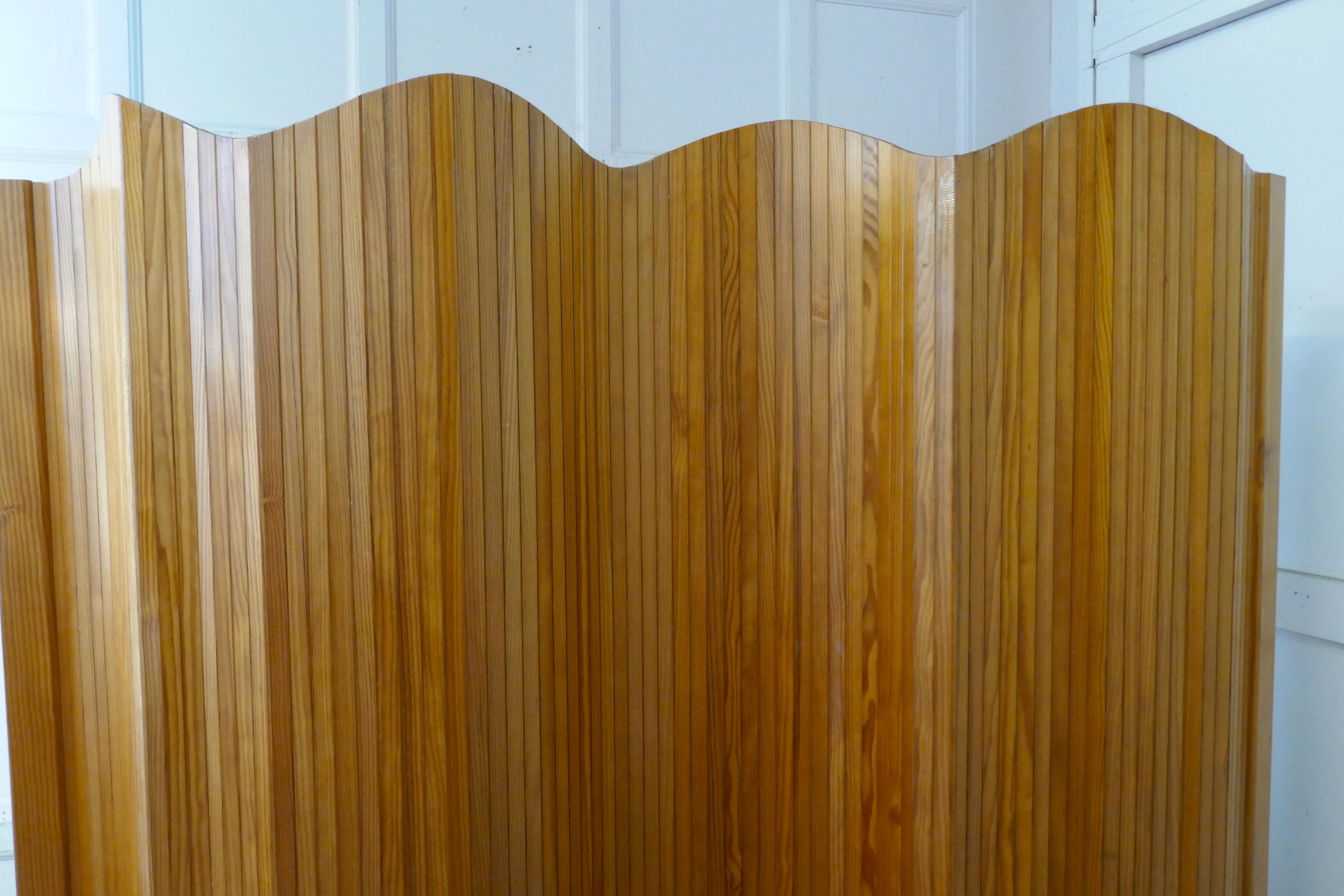 French Art Deco tambour room divider screen

This is a tall Art Deco Wooden Screen, it is made from golden beech, the top edge has waved shape
As it is tambour screen (made from wooden slats) it can be rolled up when not in use
The screen looks