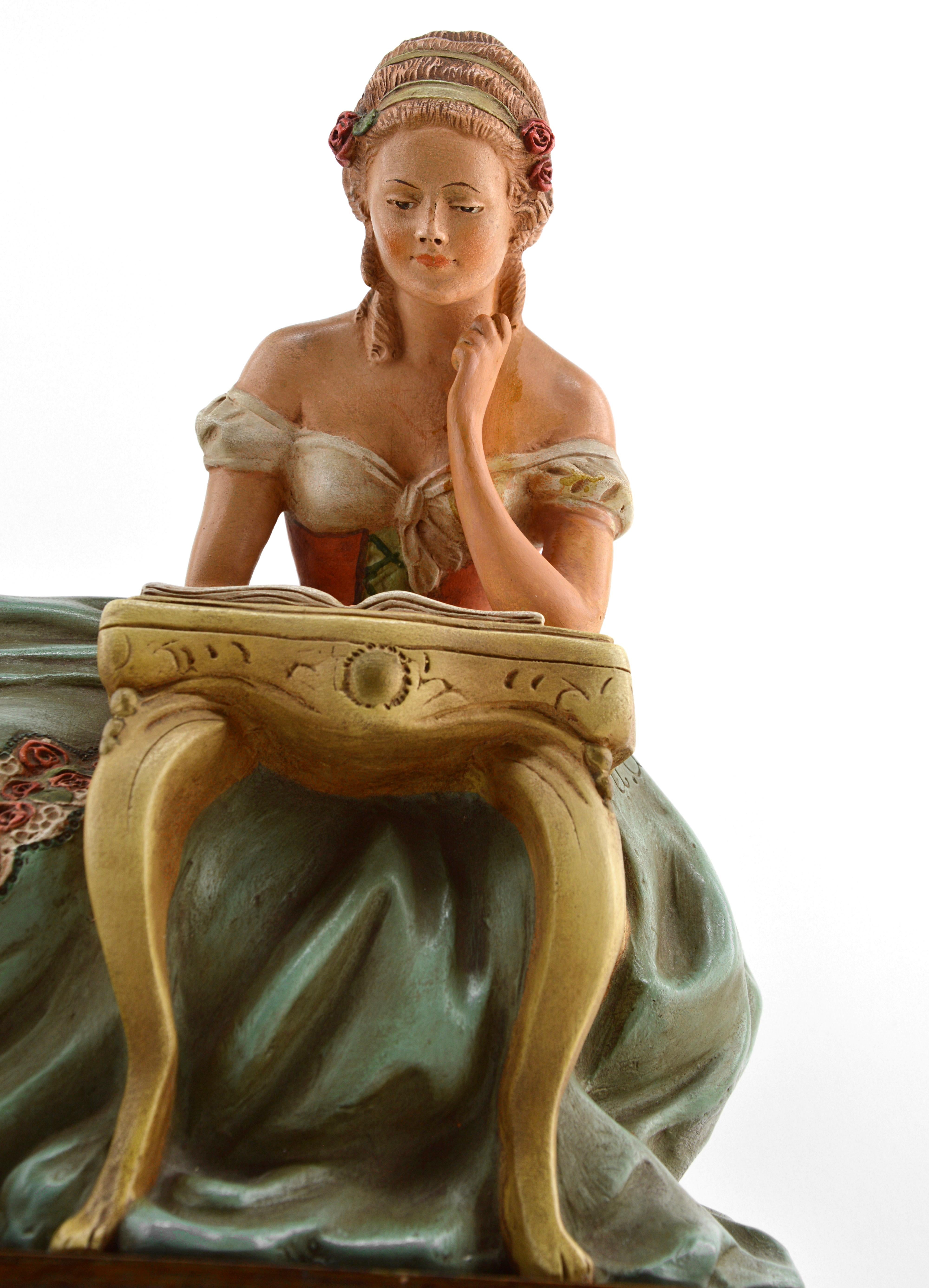 French Art Deco terracotta statue by Ugo Cipriani (1887-1960), France, 1940s. Lady reading. Polychrome patina. Macassar base. Measures: Width 15