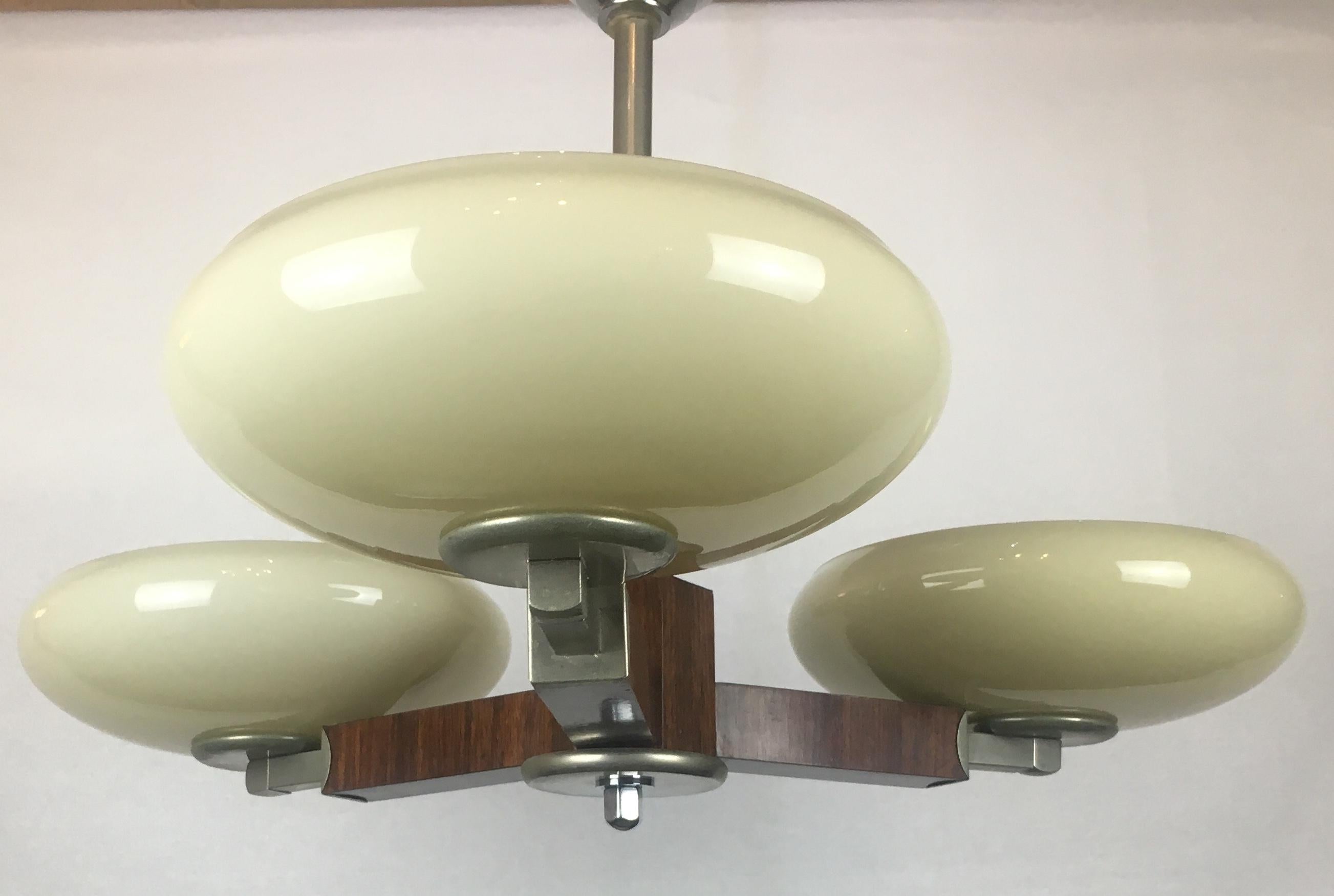 A stylish French Art Deco chandelier with pale yellow opaline shades. This very nice decorative piece is made of rosewood and chrome. Originates from the historical center of French Art Deco capital, city of Nancy.

 