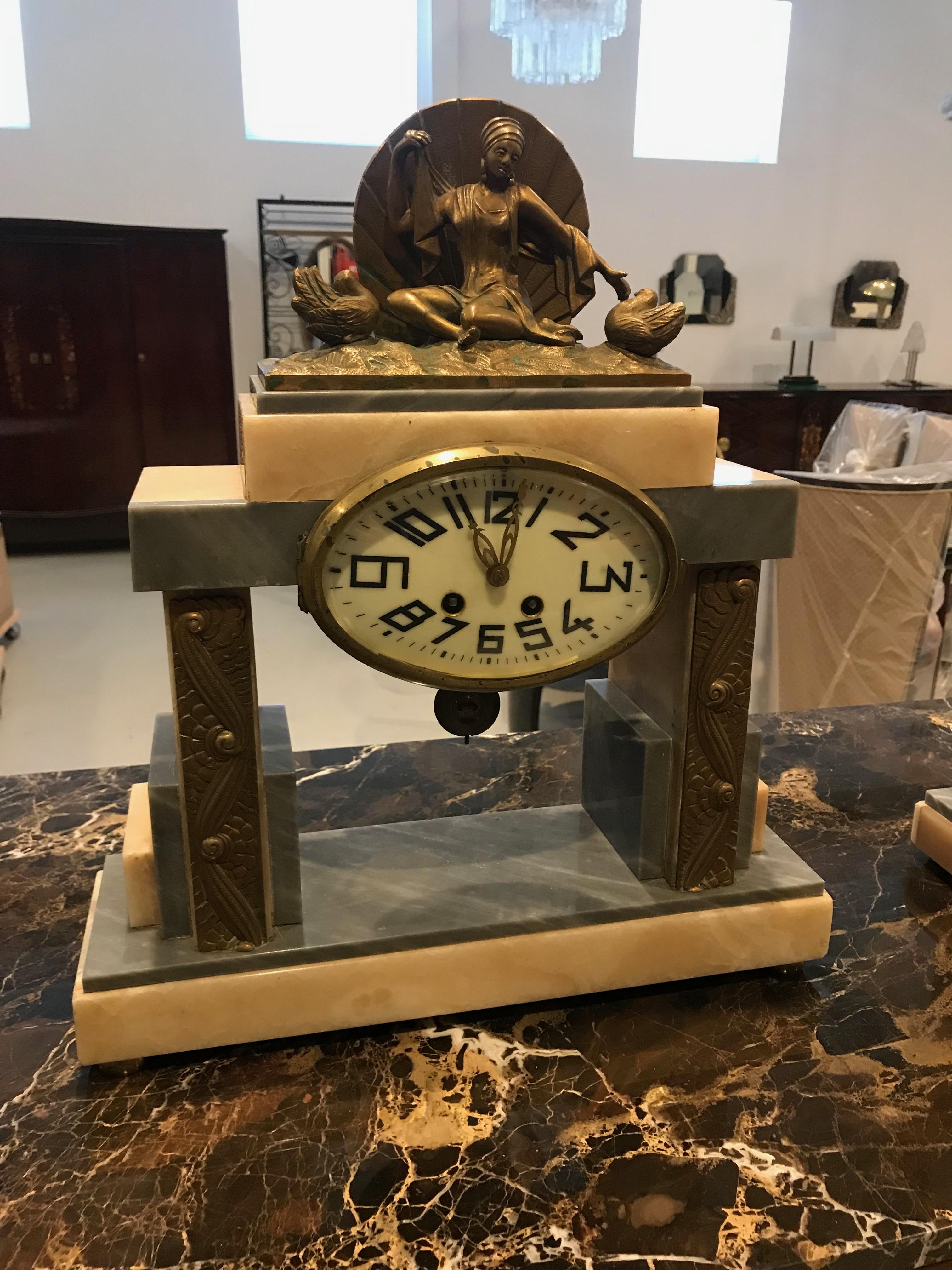 Reloj francés Art Decó de tres juegos. Tiene una hermosa escultura femenina de latón patinado en la parte superior del reloj de mármol central. Flanqueado por dos elementos Deco de mármol a juego. Increíble uso de los detalles Deco en toda la casa.