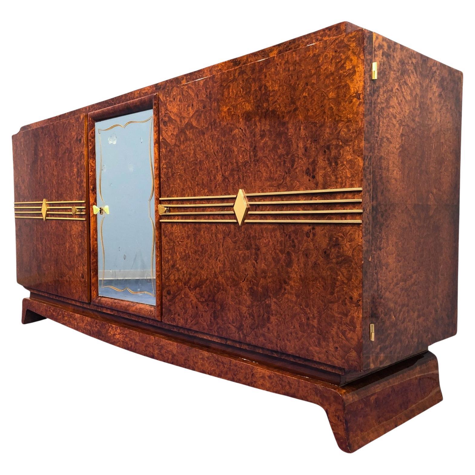 Elegant buffet Art Deco en thuya avec de précieuses incrustations de laiton sur les portes, 
la porte centrale est en  verre avec un tiroir intérieur. Intérieur en orme.
Les petites marques sur le miroir peuvent, si nécessaire, être remplacées par