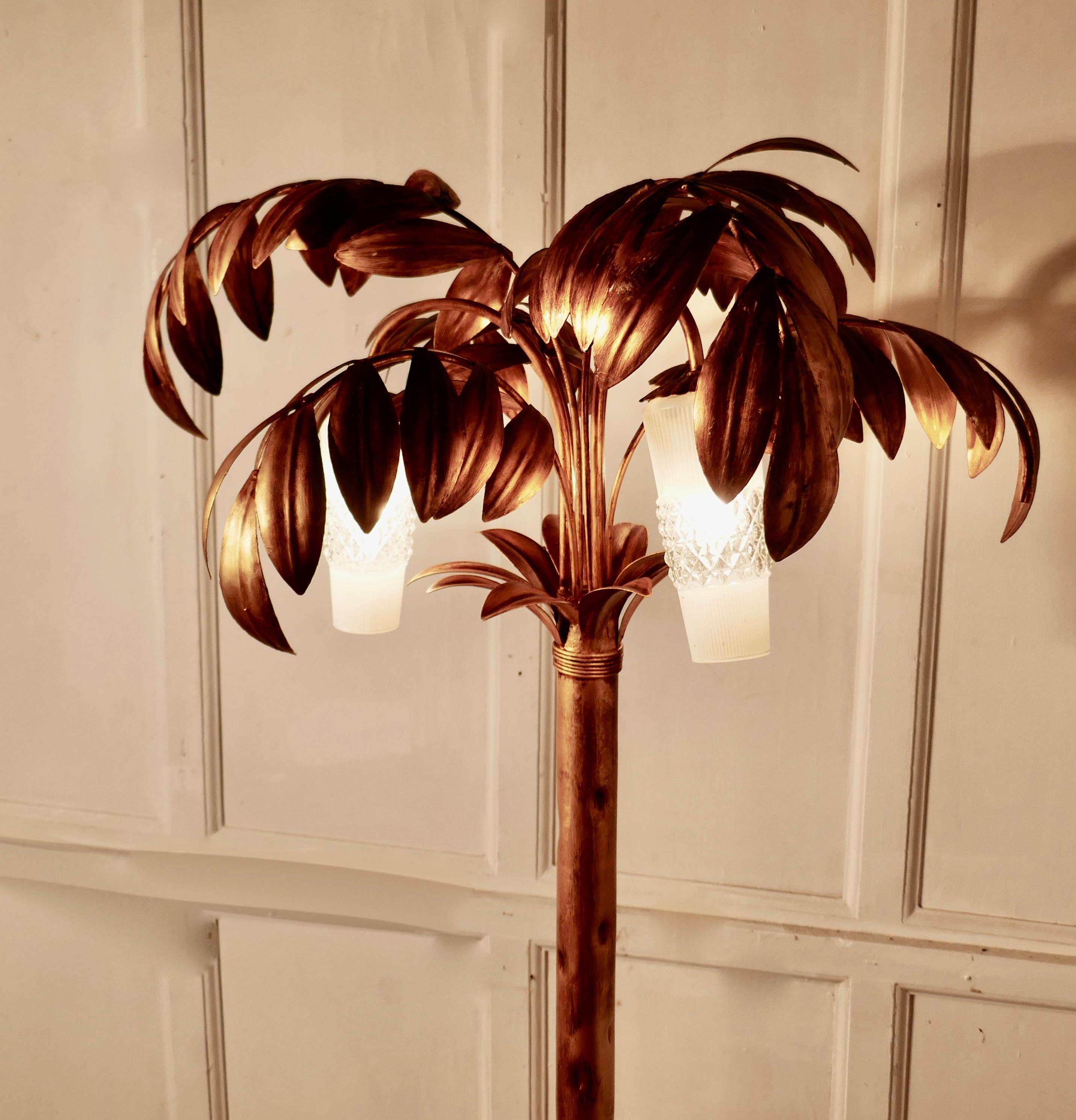 French Art Deco Toleware gold palm leaf floor lamp

This is an exciting one off piece, the lamp is floor standing, but not a very tall piece, it has large palmate gold leaves fanning out from the stem partly concealing three retro glass lampshades