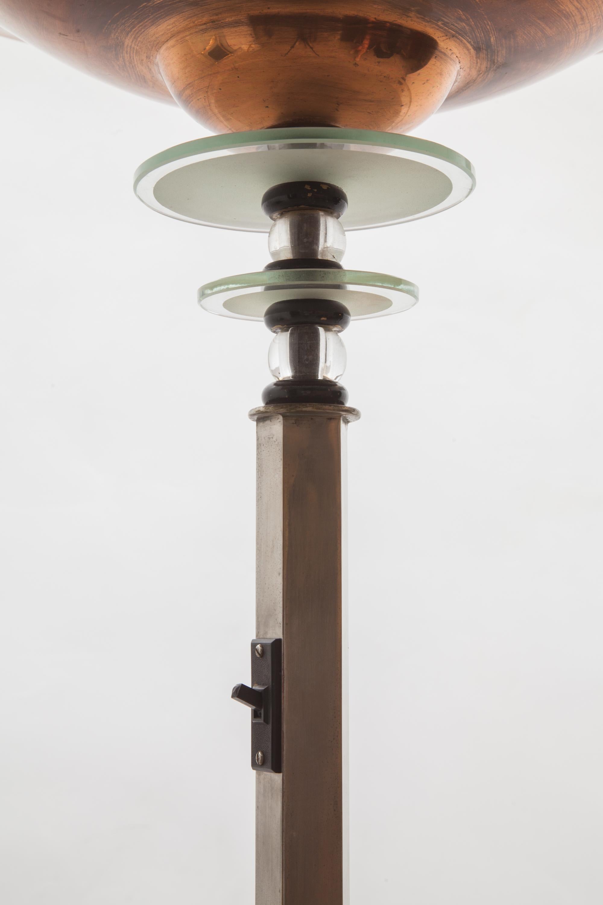 This Classic French Art Deco torchiere is from the 1920s.The brass base is connected to a hexagonal stem in nickel rice on to wear the brass shade and shine the light upwards with a suspension of two faceted and etched glass rings and beads which