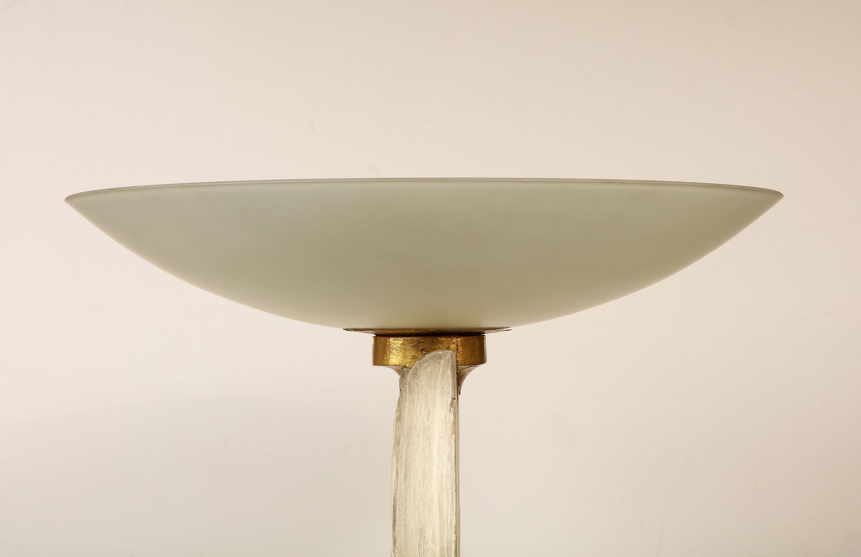 French Art Deco Floor lamp having a carved and painted wood shaft in a foliage motif  topped with frosted glass diffuser, on a rectangular painted wood base with brass and giltwood trim. The base on wheels. 