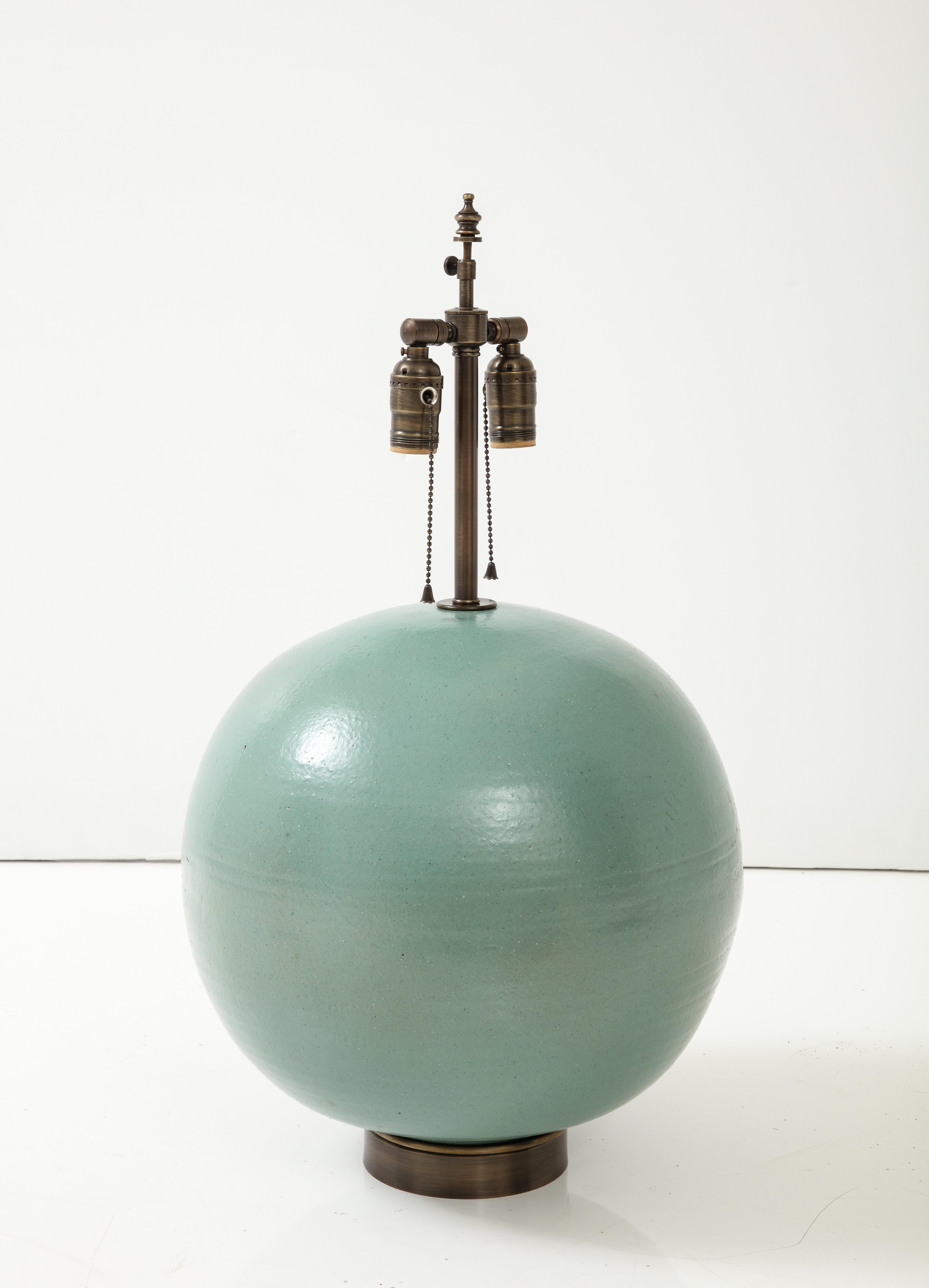 French Art Deco hand thrown large ceramic lamp with an orange peel Turquoise matte glaze sitting on bronze base. Lamps have been rewired for use in the USA by an UL listed electrician. 75W max bulbs. 

Lamp circumference is 47 inches (15 inches in