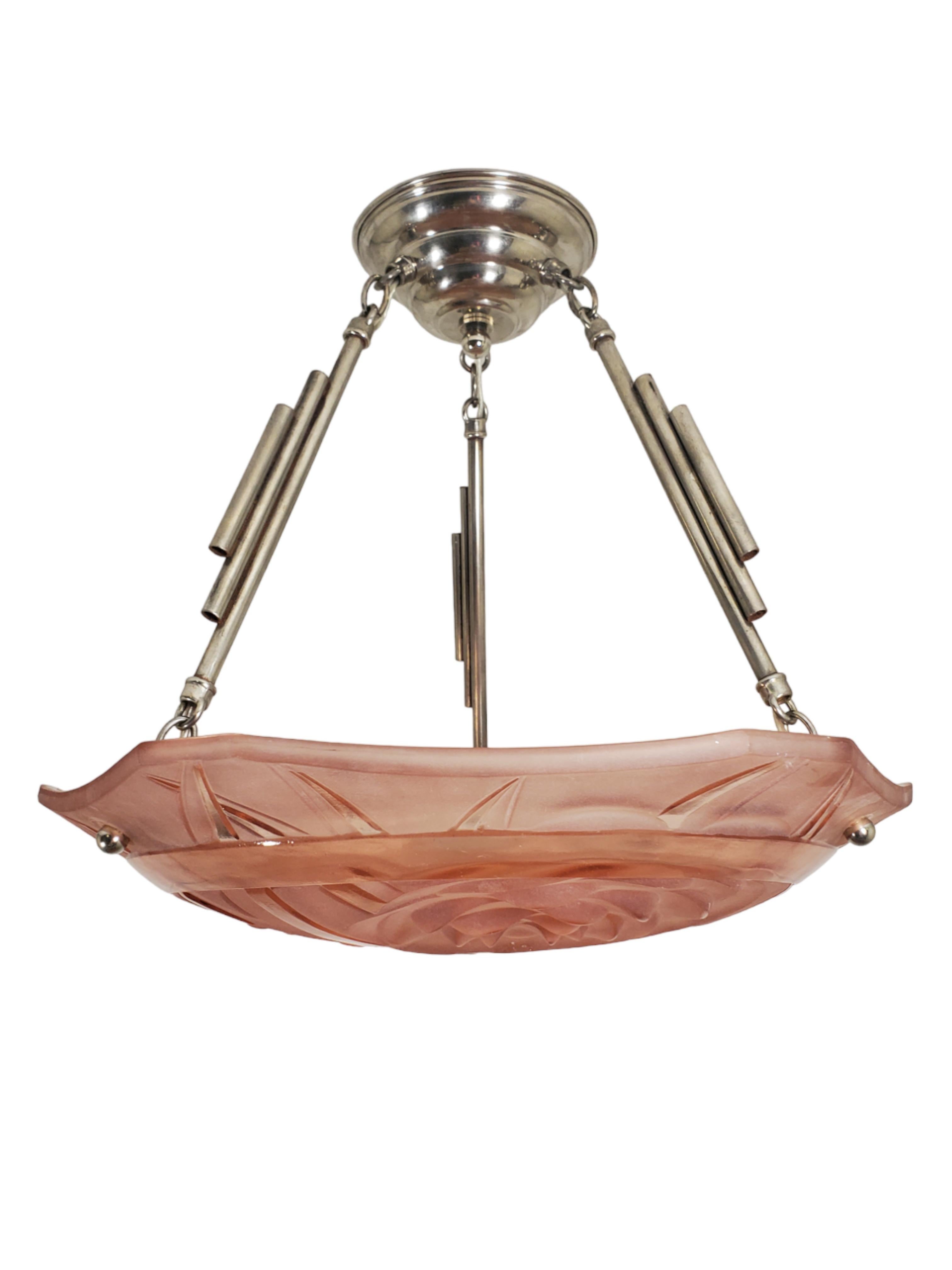 An original French Art Deco unusually shaped twelve sided chandelier in peach blush frosted art glass, attributed to Andre Hunebelle.
 The coupe features three clusters of protruding three dimensional stylized chrysanthemum floral motifs elegantly