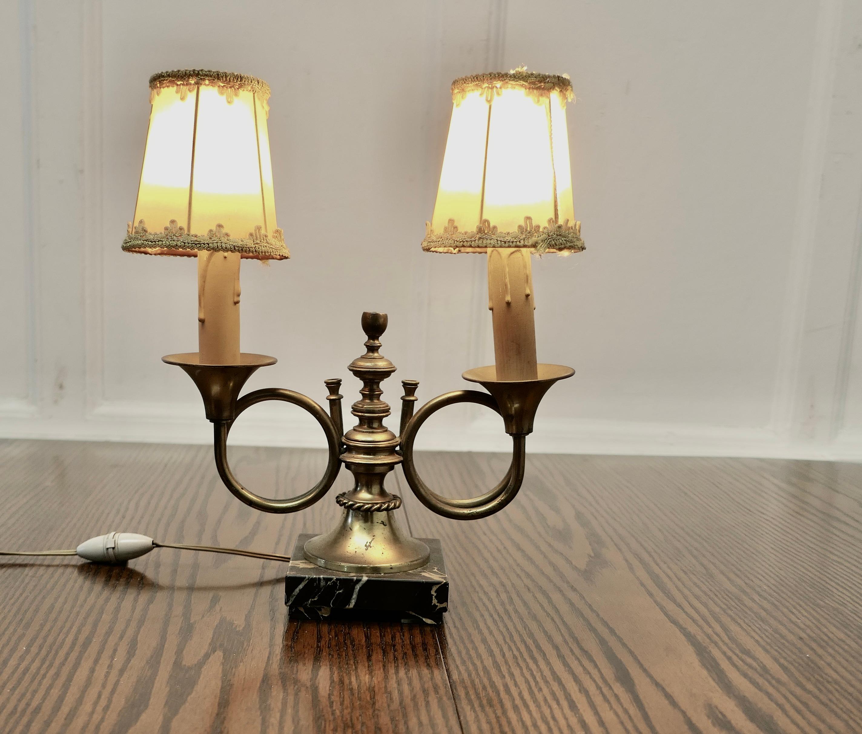 French Art Deco Twin Table Lamp, Hunting Design

This is a charming piece, it is made in brass and is set on a marbel stand, the lamp has 2 branches each in the form of circular horn with a delightful hand made shade, the lamp works well with or