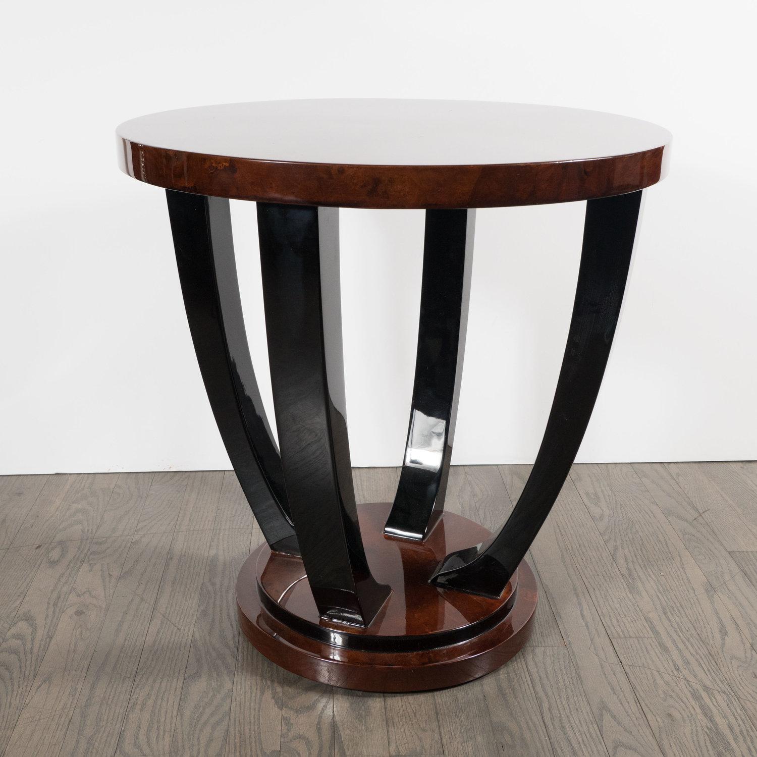 This stunning Art Deco Gueridon Table was realized in France, circa 1935. It features two round book-matched walnut tops connected by curving black lacquer supports. Scroll form feet, executed in black lacquer, peak out from beneath the lower