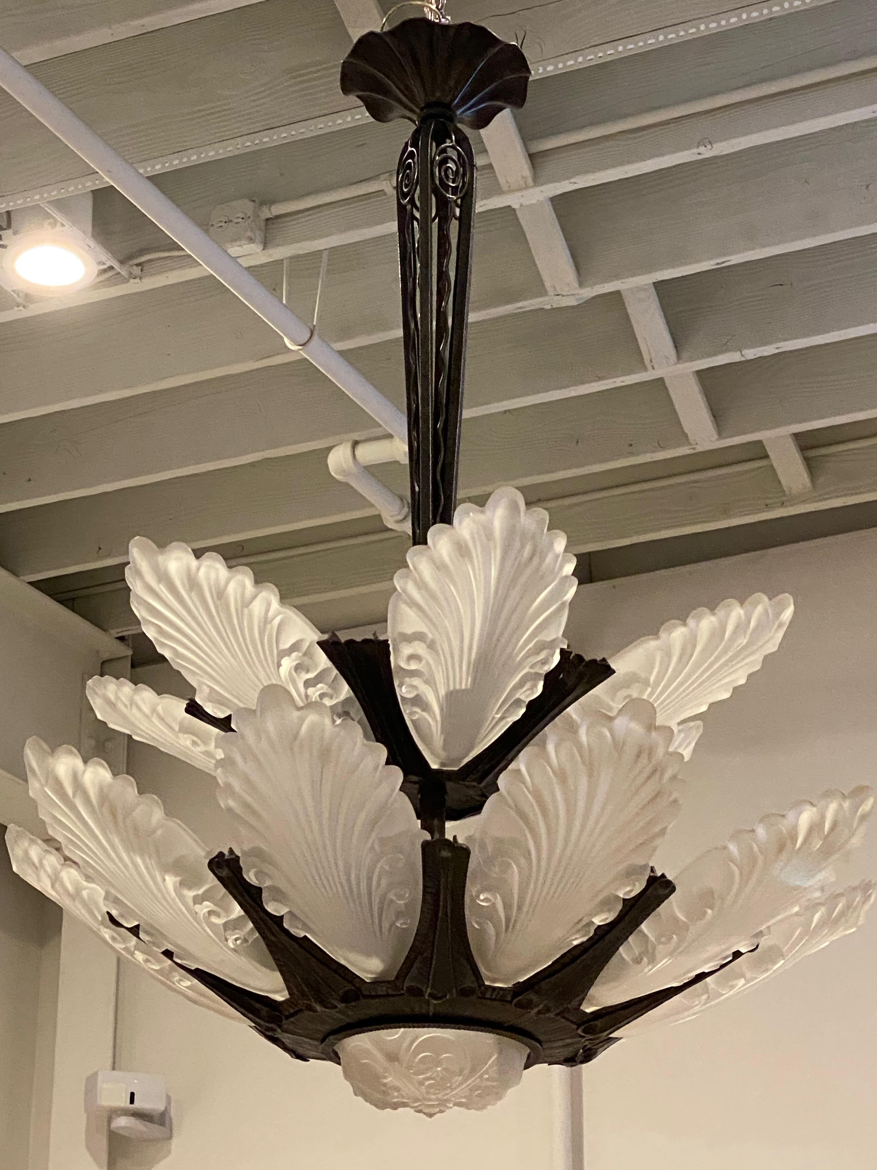 Lampadario francese Art Déco composto da due livelli. Il livello superiore ha sei pannelli di vetro trasparente stampato, mentre il livello inferiore contiene nove pannelli di vetro. Per un totale di 15 pannelli di vetro. Il vetro è inserito in una