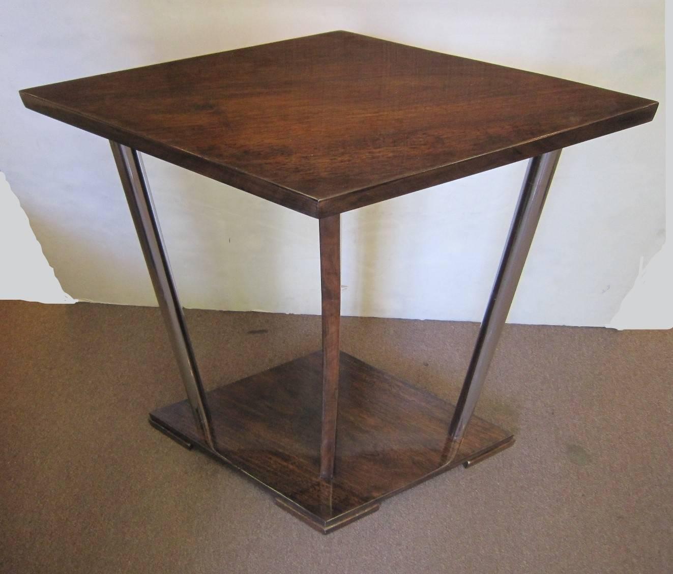 French modernist lacquered walnut side table, architectural in design with cubist lines. The diamond shaped top is held by decorative nickeled bronze tubular supports and a central slab brace, ending in a matching diamond base.
Attributed to Andre