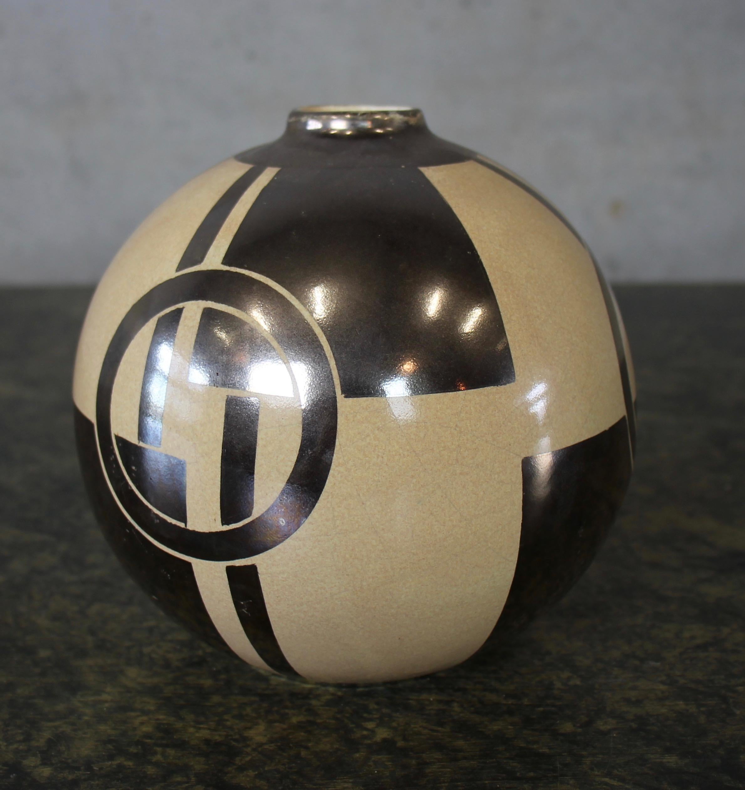 This French Art Deco vase dates back to the 1920s and impresses with its clear and graphic design. The ceramic itself has a bright glaze and the pattern shines silver. Even without flowers, the vase is an eye-catcher and beautiful Accsoir on a
