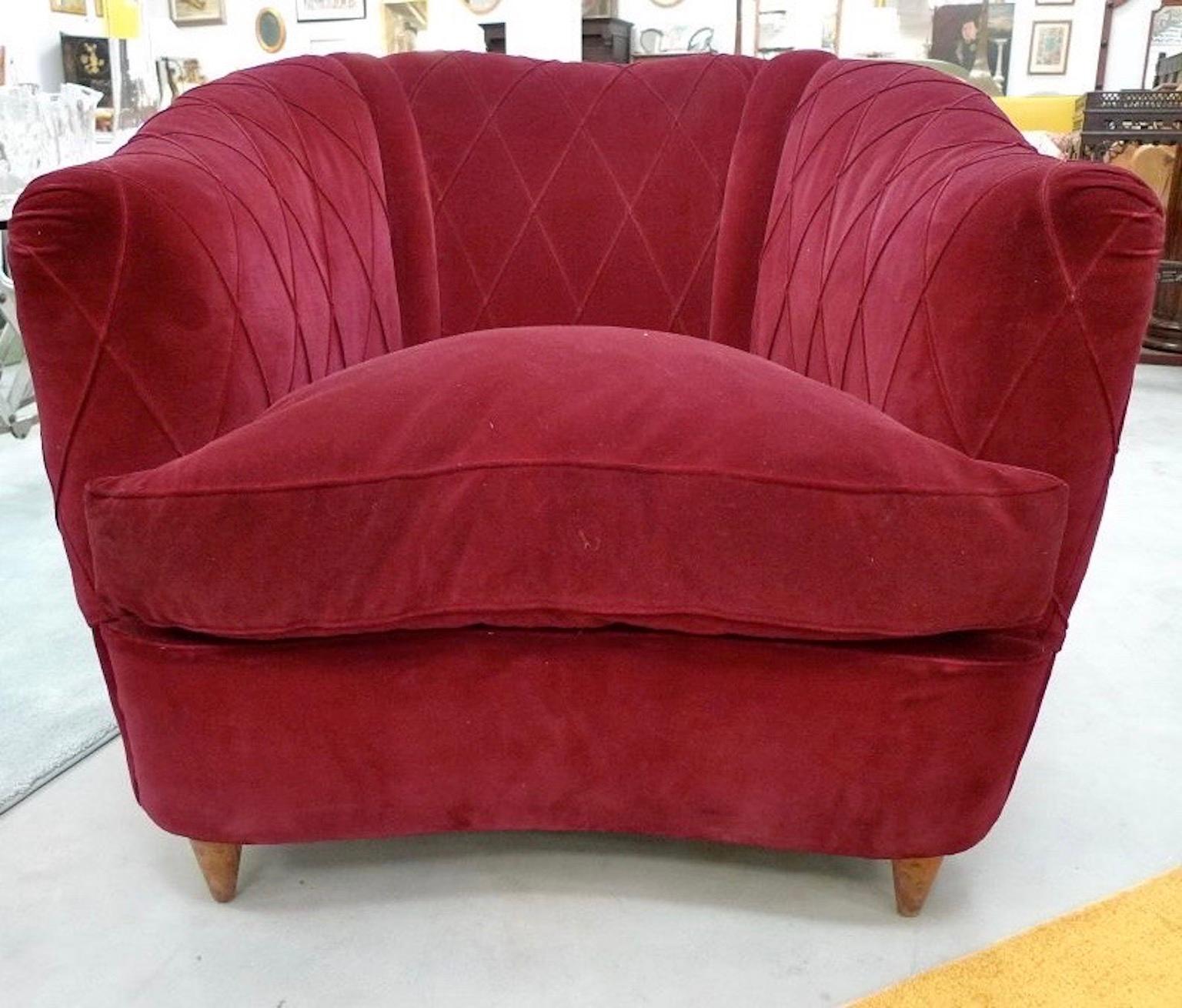 Lovely French 1940s upholstered armchair in curved-back form with distinctive croisillon diamond-shaped stitching on the burgundy velvet. 
Plump loose seat cushion filled with down feathers.
Tapered wood conical legs.

Companion sofa is sold.