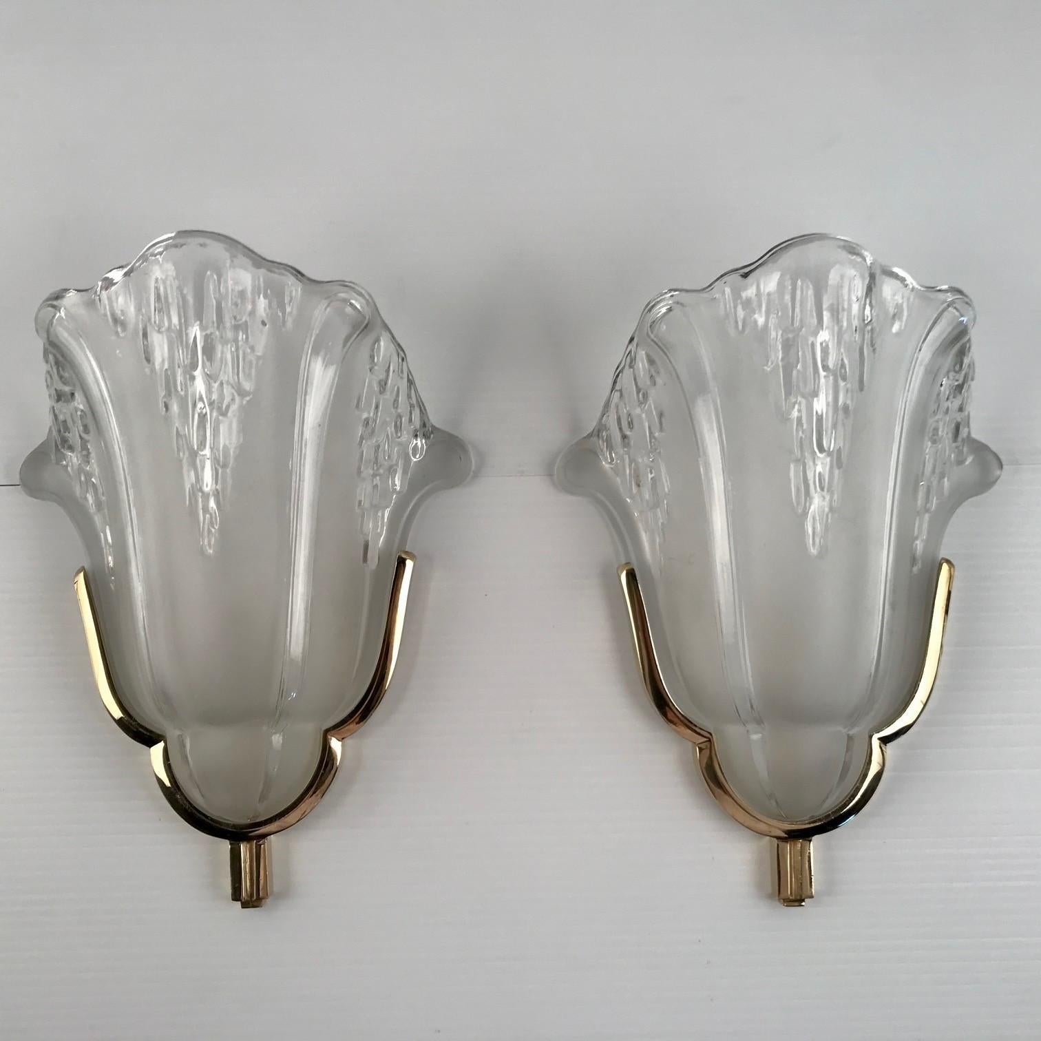 A wonderful set of four french art deco wall sconces in polished brass. All four glass shades are marked “PETITOT FRANCE”. And the Petitot brass is marked and numbered on the back. A very nice and extremely hard to find model from the mid 30ties.