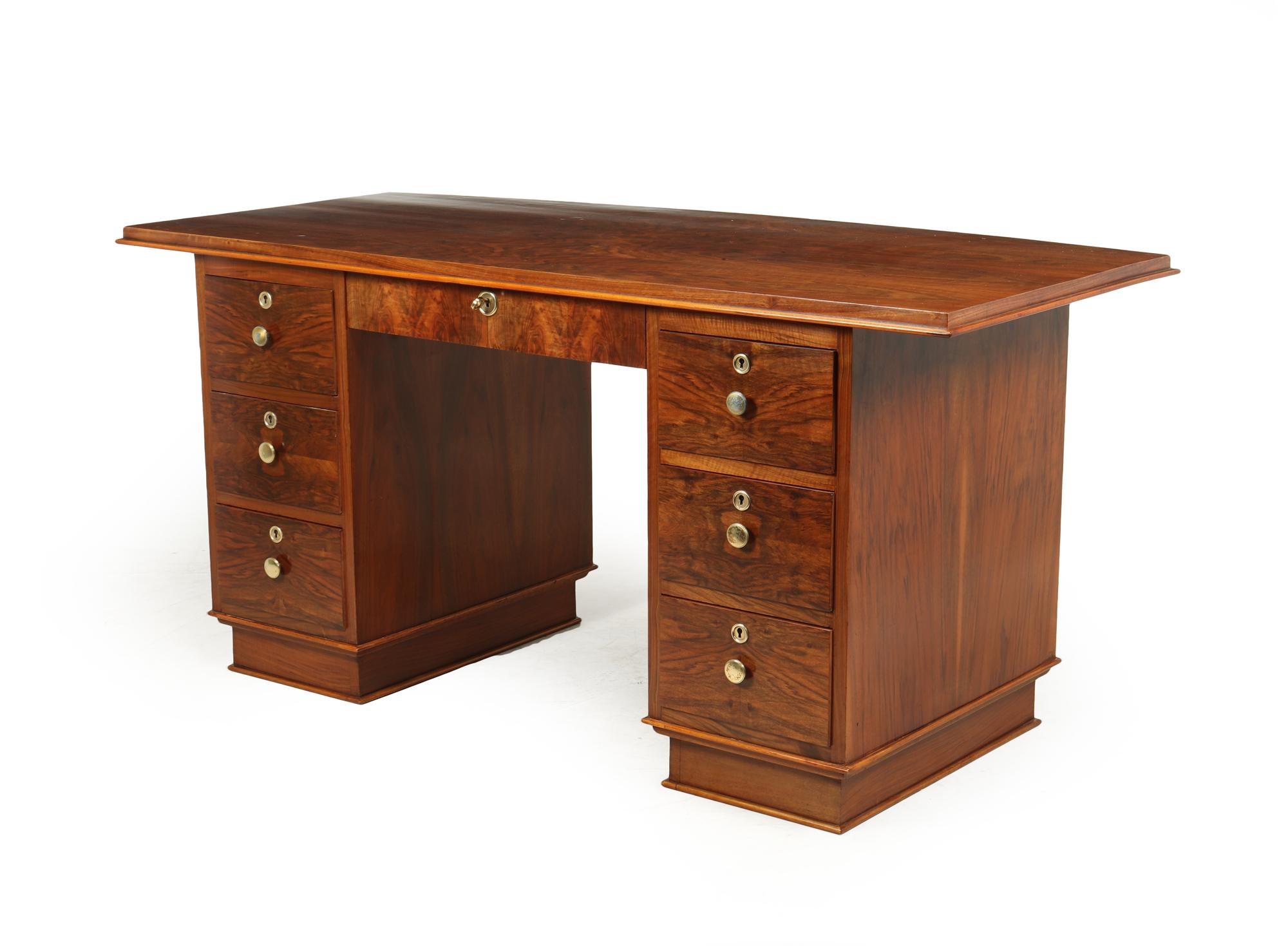 A seven drawer desk produced in France in the 1930’s it has two pedestals a central drawer and a large overhanging curved top. The desk has been fully restored and polished by hand alto there is still some minor indentations to the top

Age: