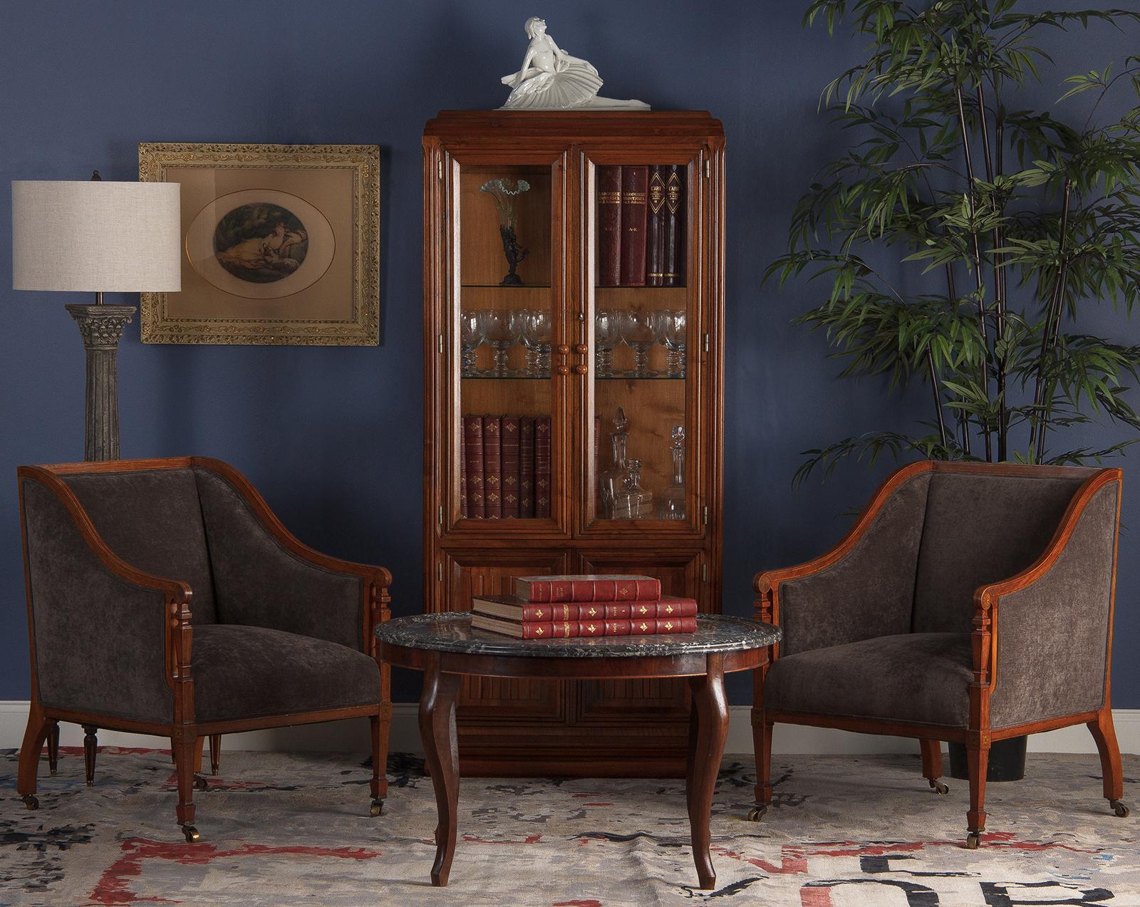 A gorgeous display cabinet made of blond walnut from the Art Deco period, circa 1930s. The top part is a vitrine with glass panels on the front and sides, two glass shelves and a mirrored glass at the bottom. The lower part rests on a plinth base