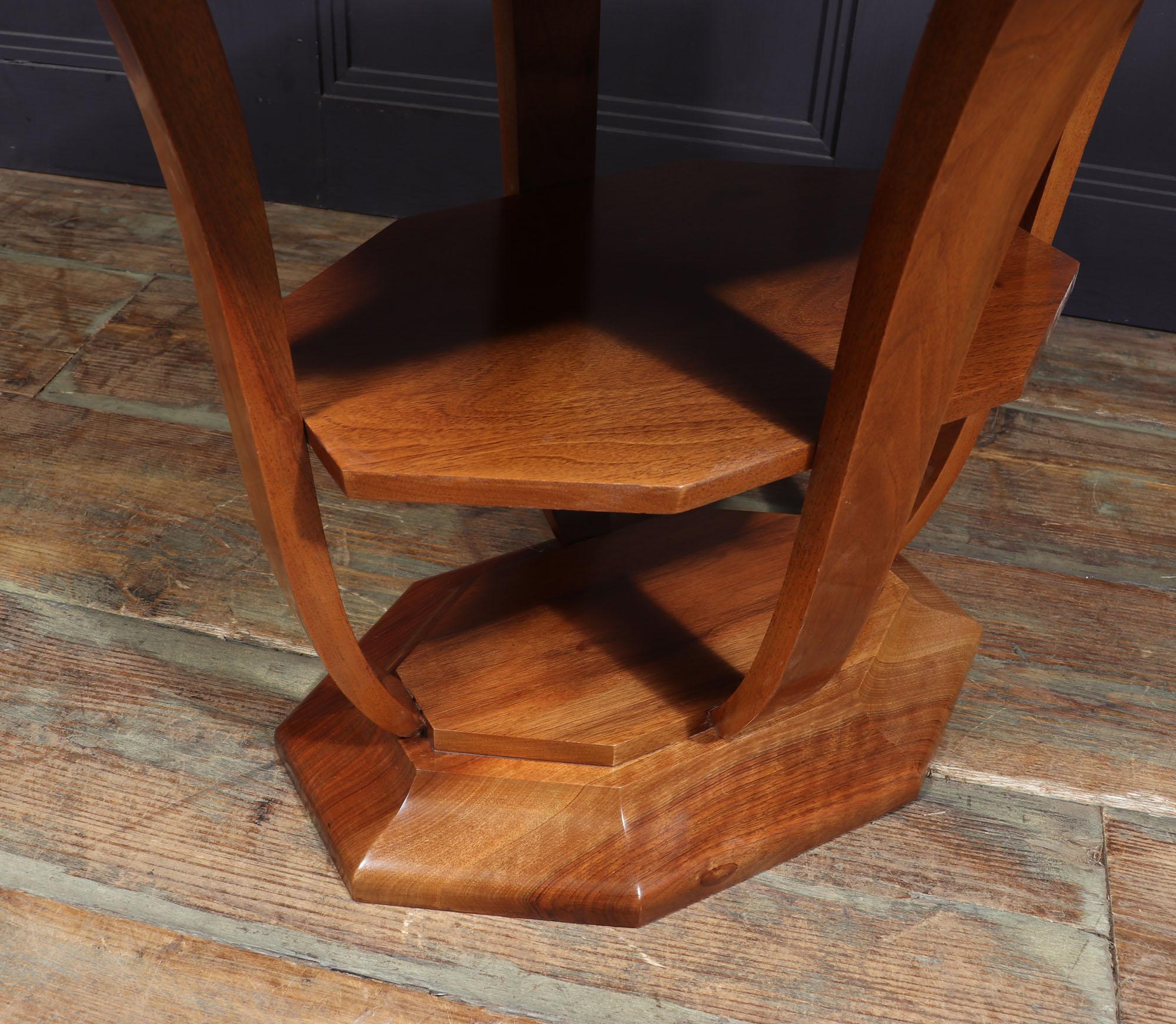 This French Art Deco walnut occasional table is a timeless piece that will add sophistication and elegance to any space. Its beautiful walnut wood finish is complemented by the two tiers, shaped uprights and heavy solid base, making it both