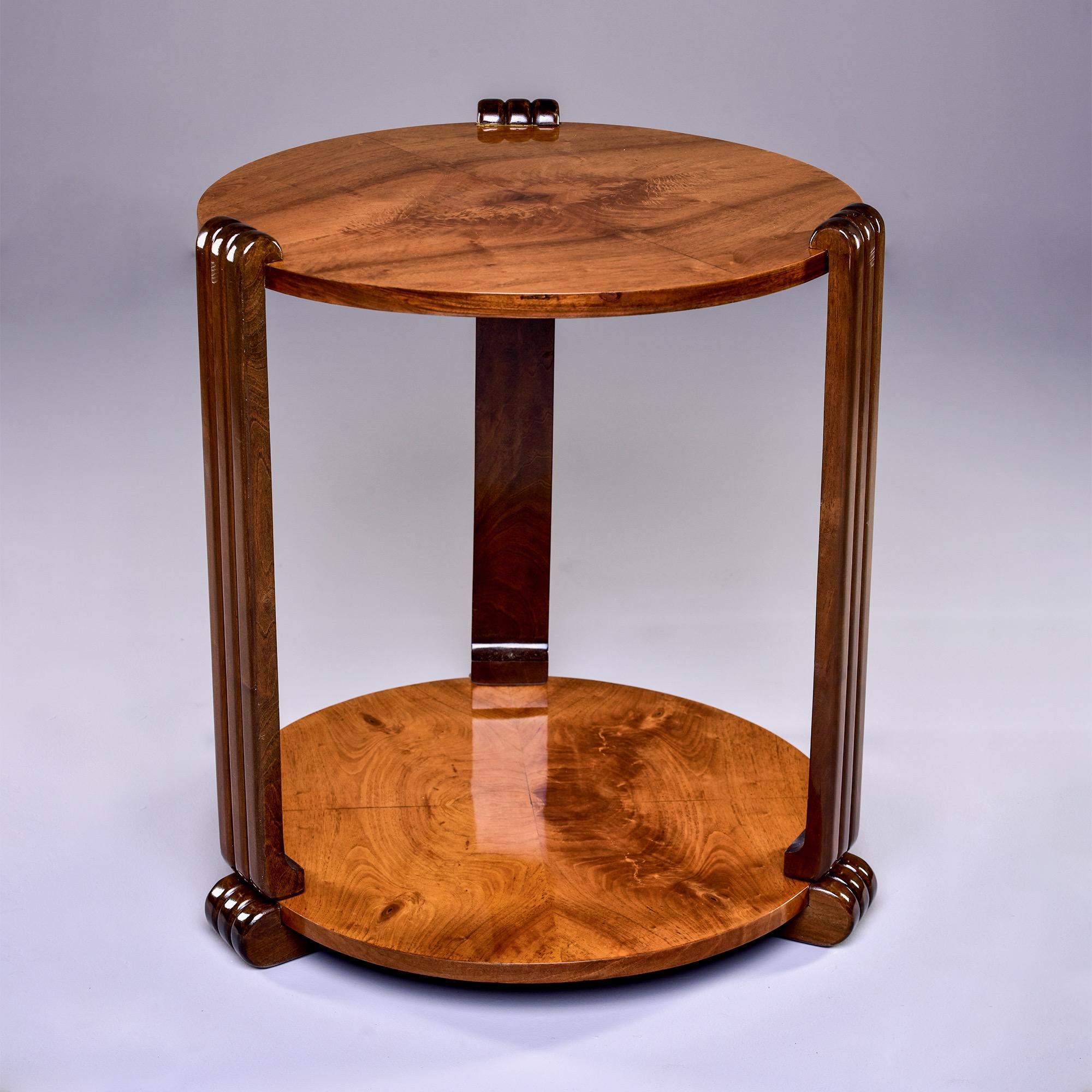 Circa 1930s French round side or center table features a highly figured walnut veneer top and base with contrasting darker reeded side supports and feet. Unknown maker. Professionally refinished.