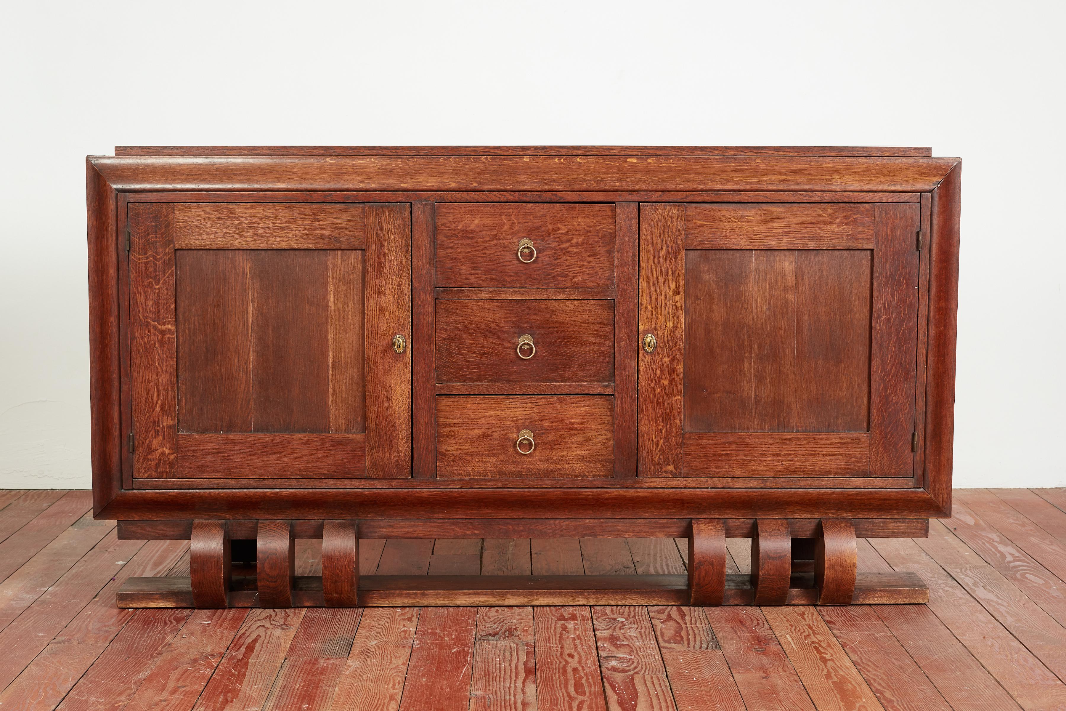 Simple walnut Art Deco cabinet with floating curved base. 
France, 1930's 
Gorgeous patina to wood, simple brass hardware with original key
3 drawers open for storage and 2 cabinet doors 