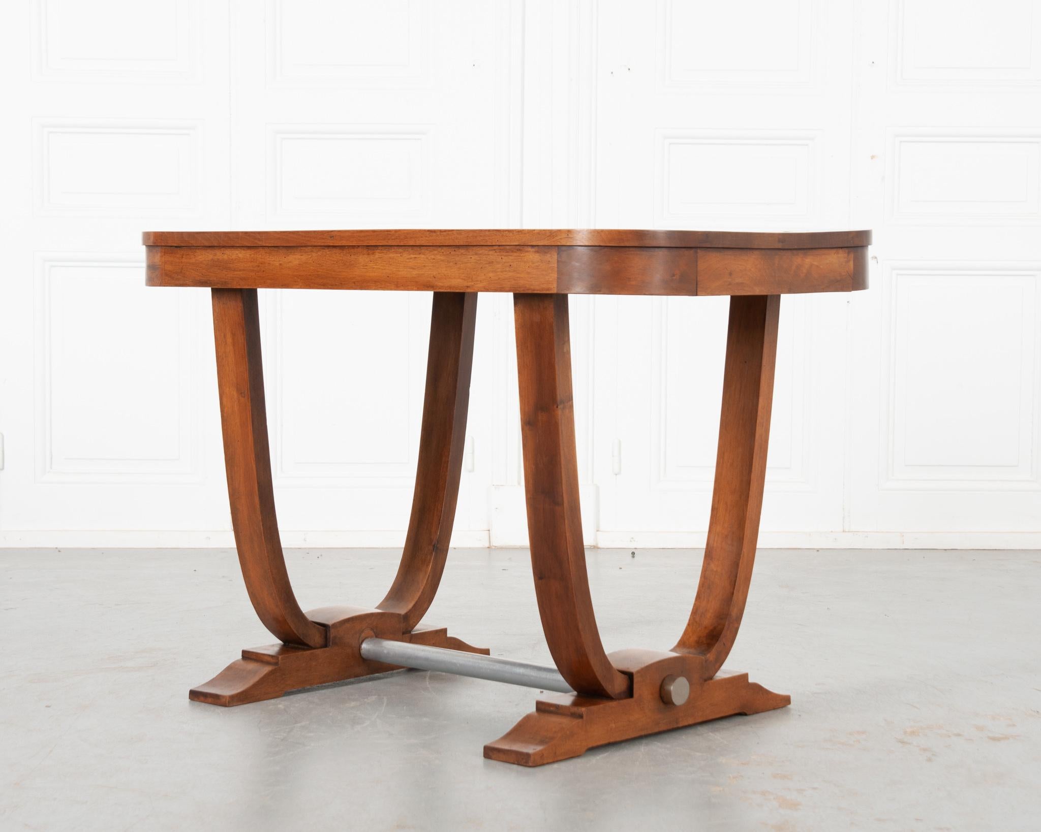 A handsome Art Deco table from France! Made of vibrant walnut that's been recently polished with French wax paste. Elegant curved edges around the top and legs give it a classic Art Deco design. Stepped feet, attached with a cylindrical metal