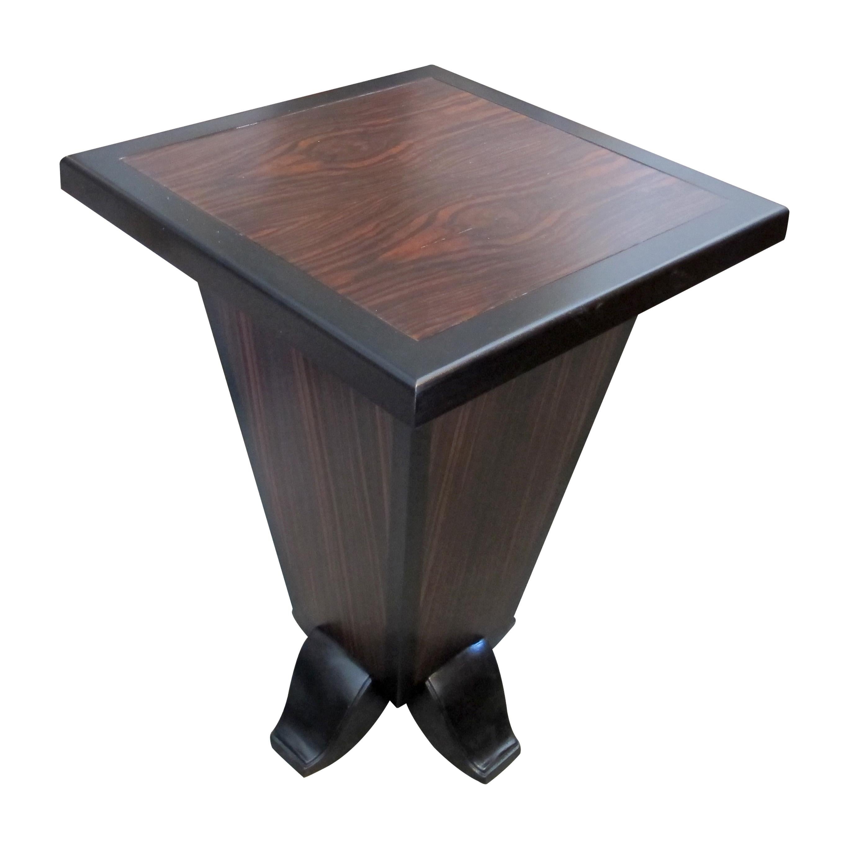 Esta mesa auxiliar francesa Art Decó presenta un tablero cuadrado con una rica chapa de nogal y un borde negro en contraste. La base tiene forma de pirámide invertida, acabada en chapa de nogal, y se asienta sobre cuatro patas negras curvadas. El