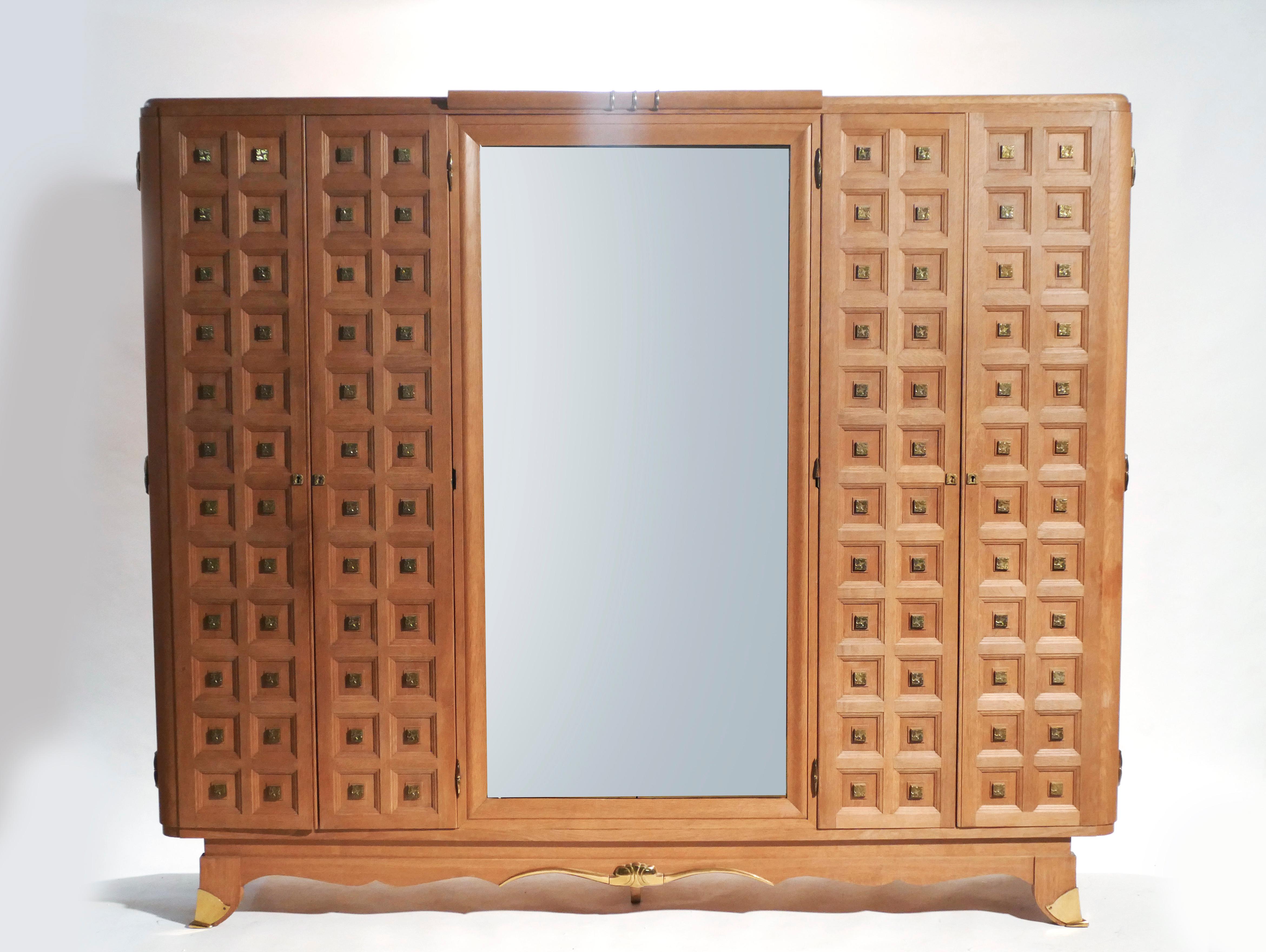 Spacious shelves and large mirror make this large oak wardrobe suitable as a bedroom armoire, or as a multipurpose and decorative cabinet in an entryway or living room. The cabin doors and feet are adorned with quality brass, and the inner shelves