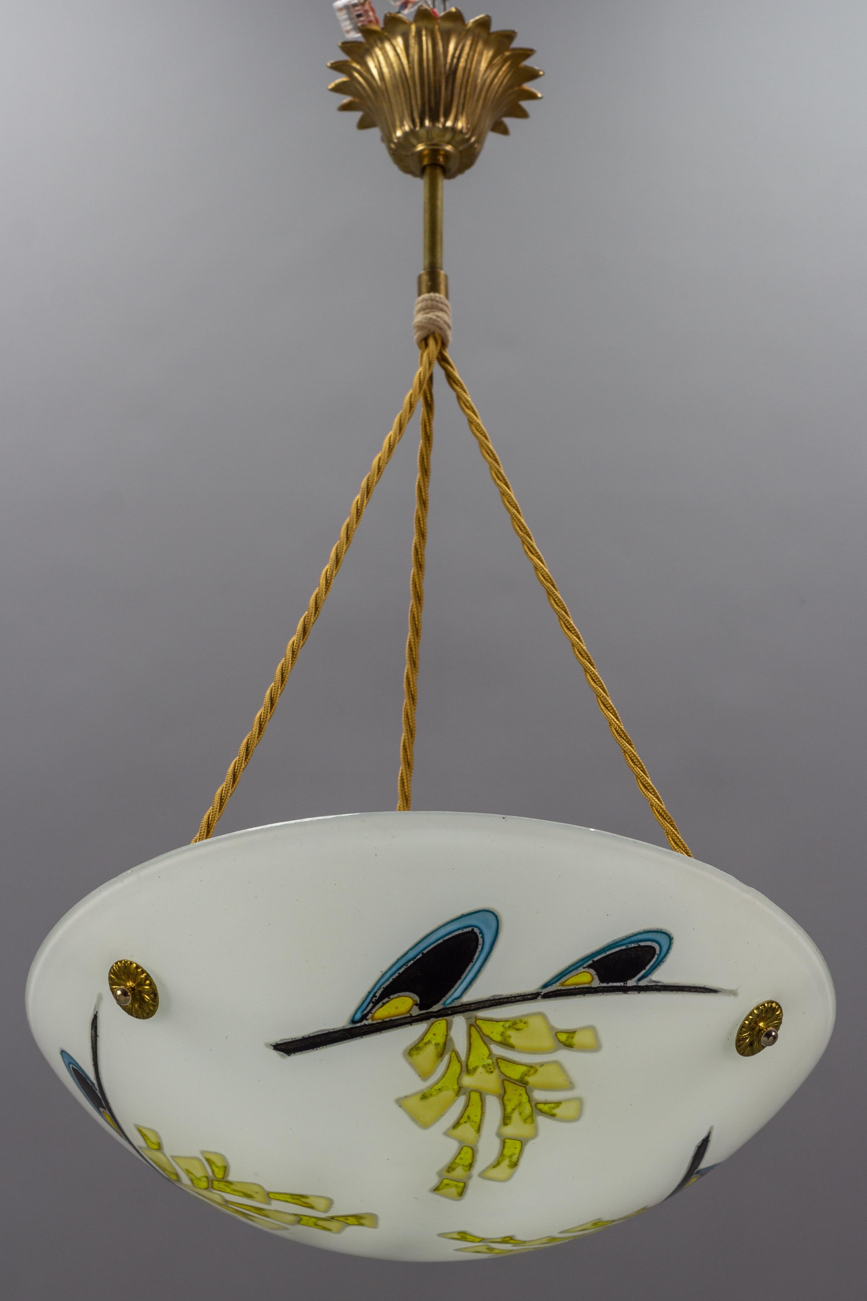 Beautiful French Art Deco pendant chandelier. White glass shade with enameled hand-painted floral design in yellow, blue, and black colors that looks wonderful both lit and unlit. Glass bowl is signed 