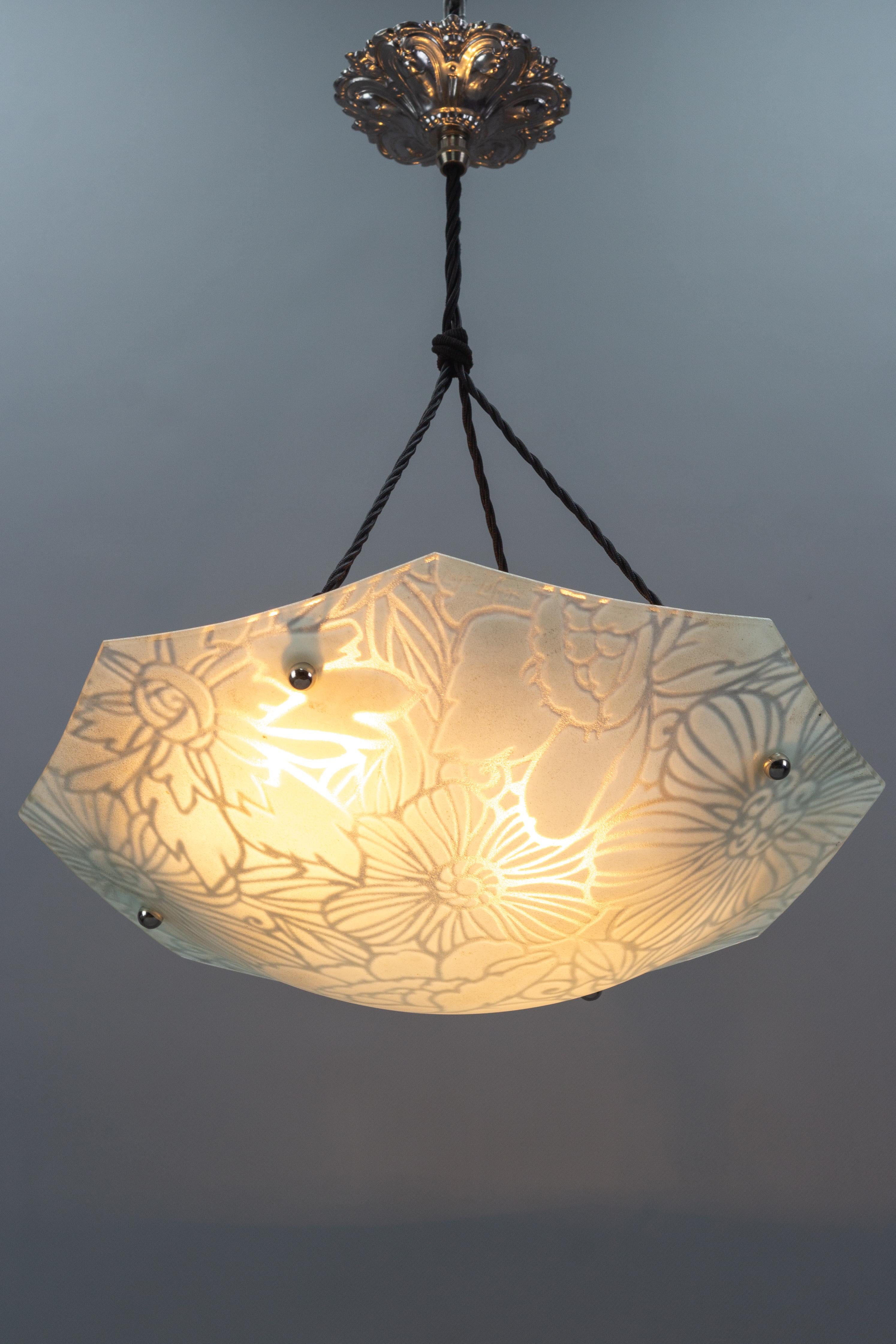 This superb Art Deco period pendant light with molded, frosted, octagonal glass bowl features a floral design in white. The beautifully shaped frosted glass shade with the enameled decoration of stylized large flowers is suspended by four cords and