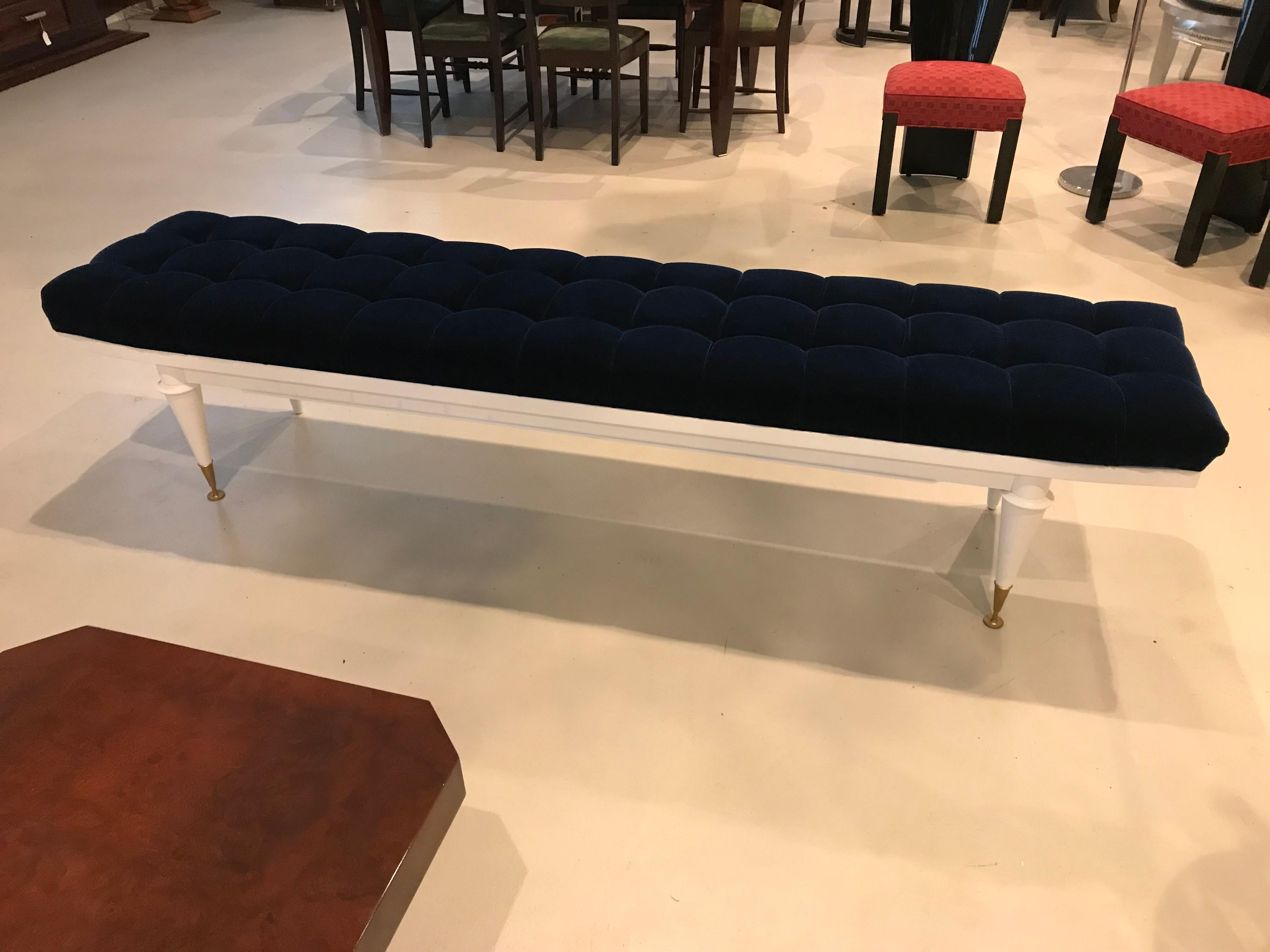 Monumental French Art Deco white lacquered mahogany sitting bench. Newly upholstered in a very high textile velvet royal blue. Newly refinished. White lacquer legs with brass caps.