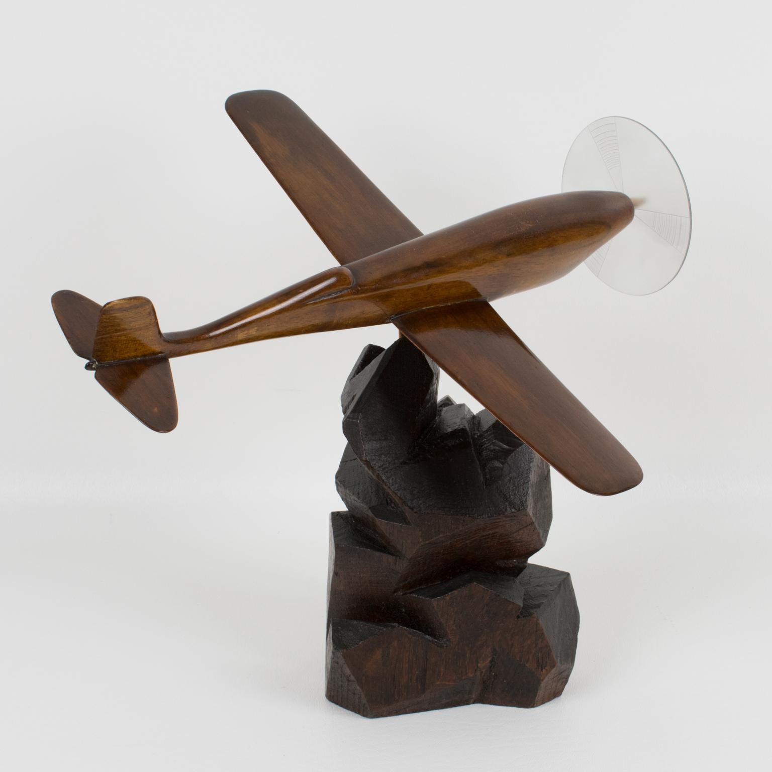 Stylish Art Deco wooden airplane model mounted on a stylized wooden plinth. This Art Deco model airplane is made with solid varnish wood. It has one large Lucite propeller (note original propeller was probably metal or wood and replaced at some