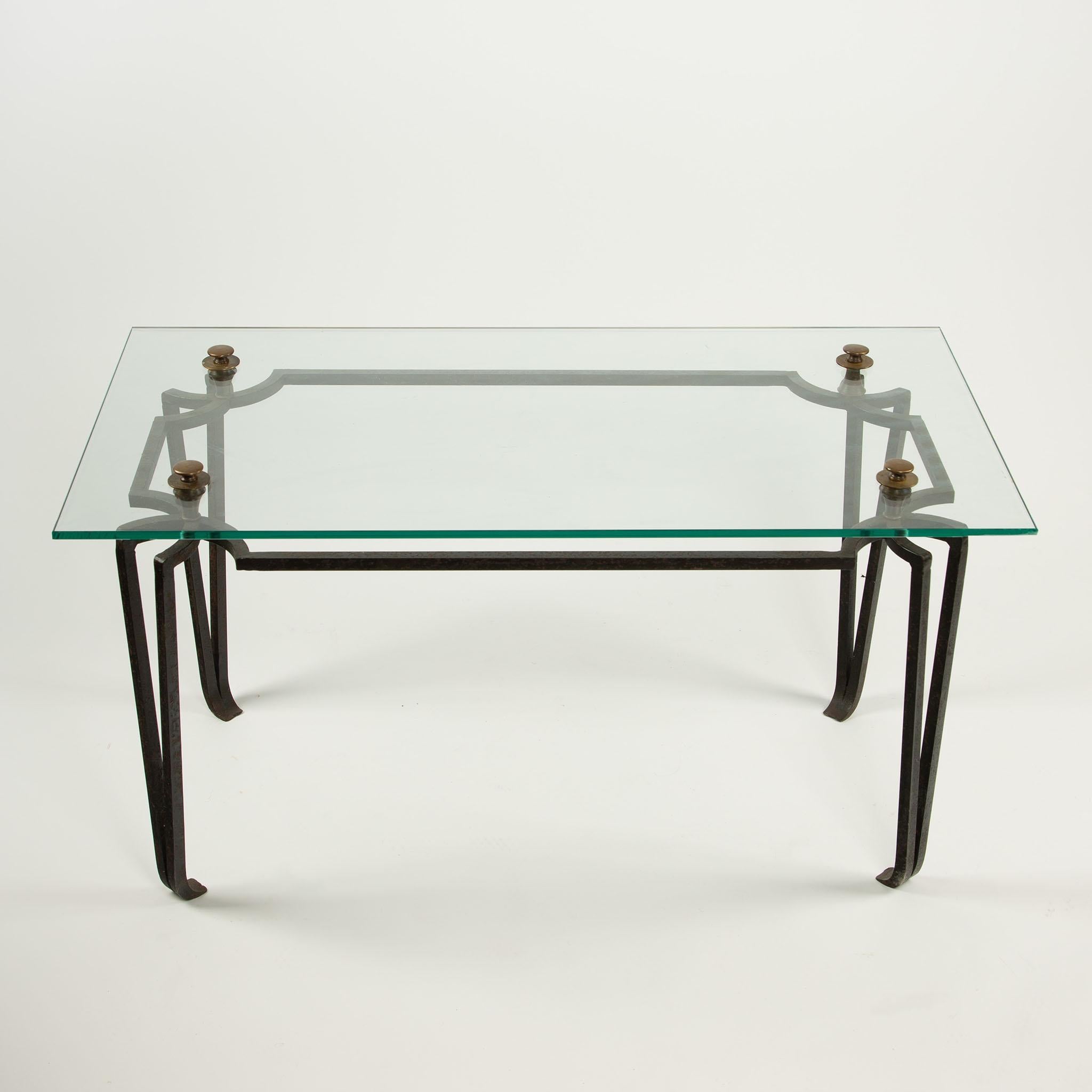 Table basse en fer forgé et verre du 20e siècle avec montures en bronze

Table basse du 20e siècle finement travaillée, avec un plateau rectangulaire en verre soutenu par une base en fer forgé avec d'élégants détails géométriques et en forme de