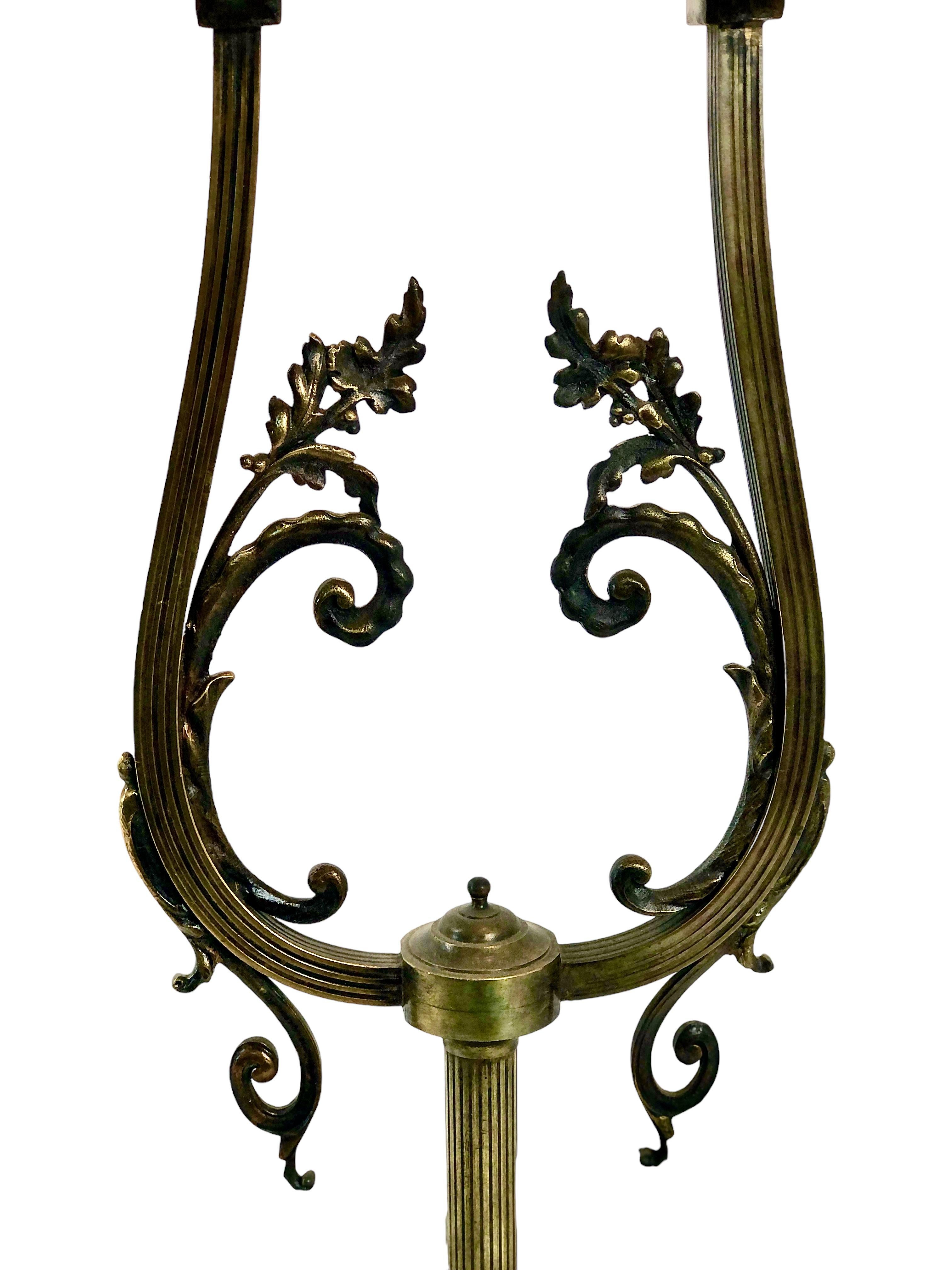Lampe de table à deux bras en fer forgé et verre moulé dépoli de style Art déco français. Cette lampe accrocheuse mesure 85 cm de haut et peut donc tout aussi bien être posée sur le sol pour éclairer un coin sombre. Posés sur une lourde base en fer