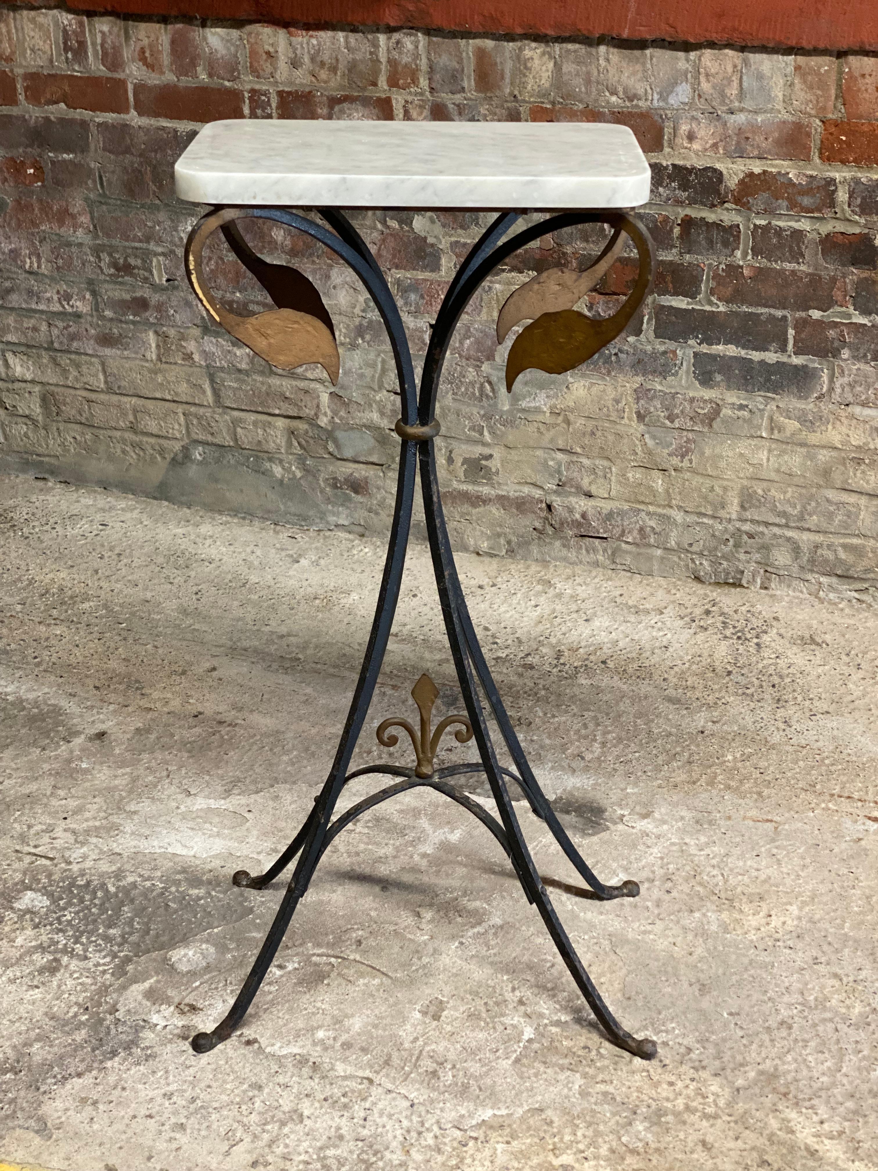 Beautiful French Art Deco wrought iron and white marble top stand. Four splayed and bundled iron rod legs with a fleur d'lis arched stretcher. The top of the stand has four languidly craning flamingo heads that support the polished white marble top.