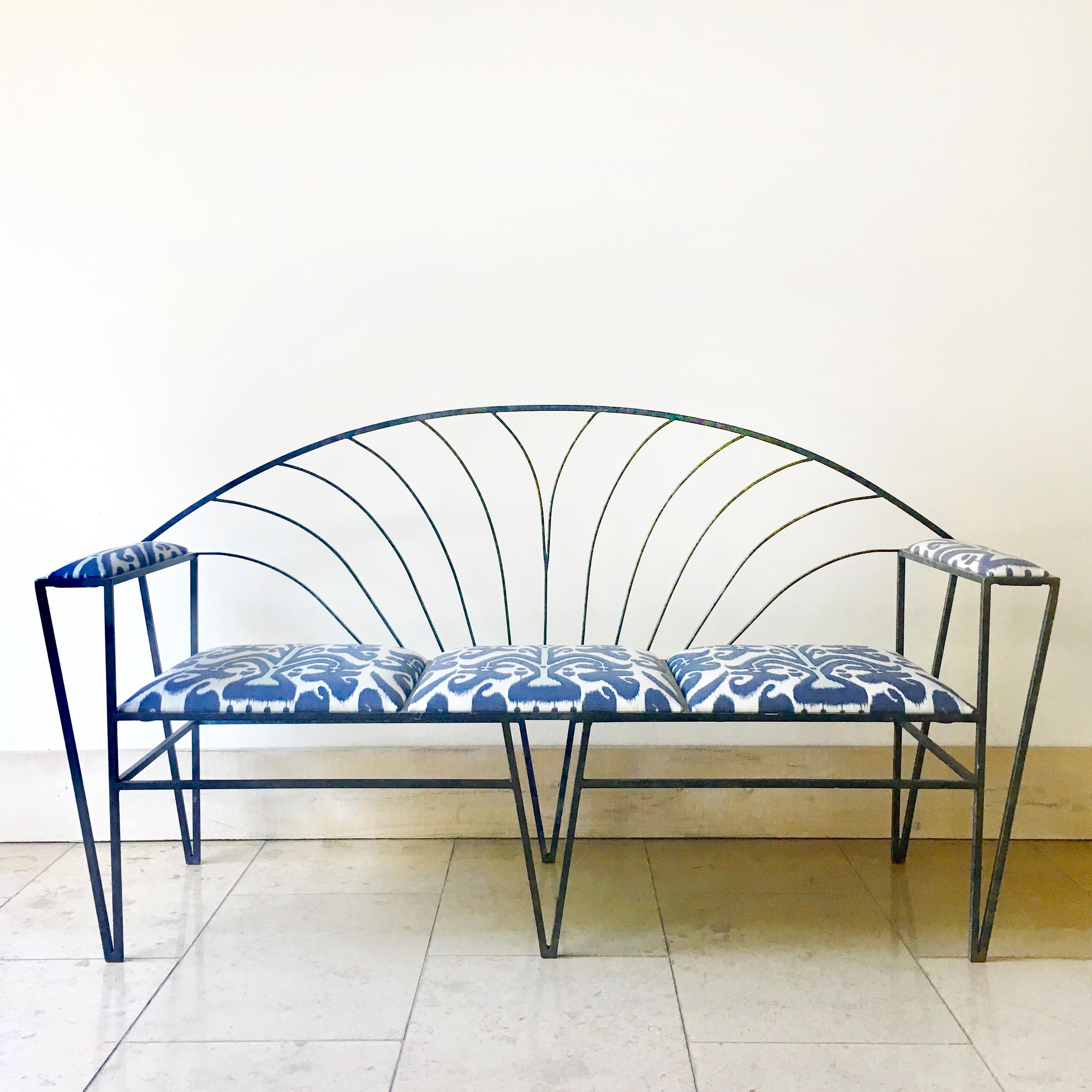 Sculptural French Art Deco wrought iron bench 1930s with removable outdoor Ikat upholstered seat pads hand finished in a rich turquoise patination.