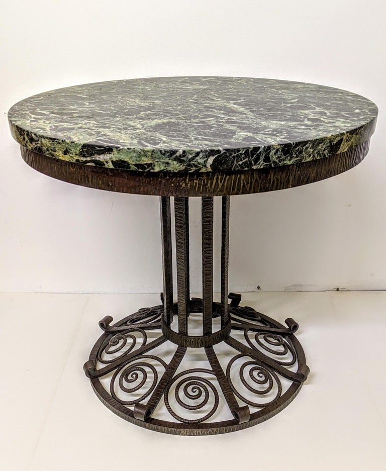 A round French Art Deco wrought iron table with a green and white marble top that can be use as a coffee or side table. 
We are the rare source that specializes exclusively in French Art Deco for over three decades, since 1991 with restoration,