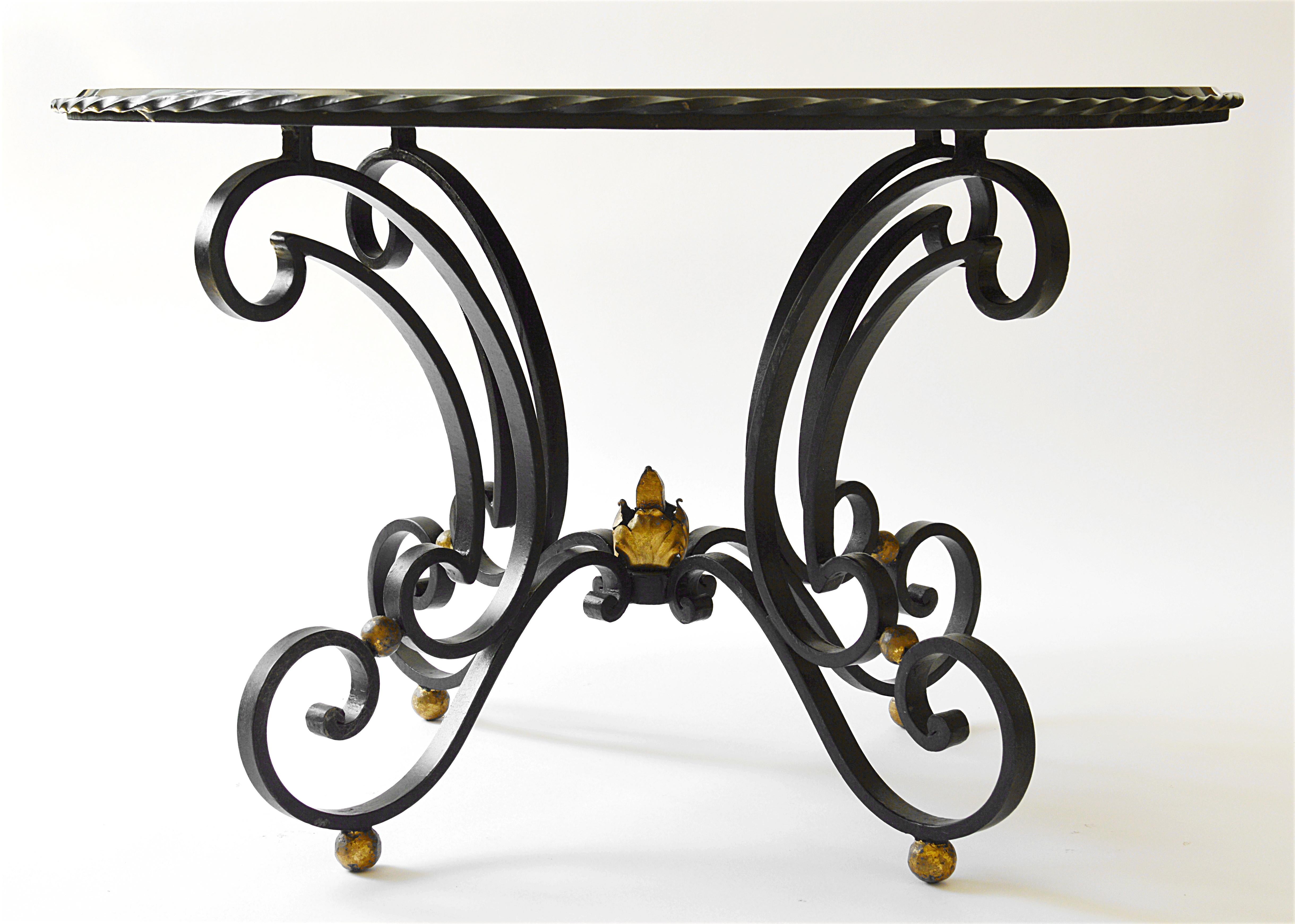 Table basse Art Déco, France, fin des années 1930. Base en fer forgé avec quelques parties dorées. La partie supérieure, en verre noir, représente un essaim d'étoiles qui brillent dans la nuit sous la forme de la Voie lactée. Ces étoiles sont