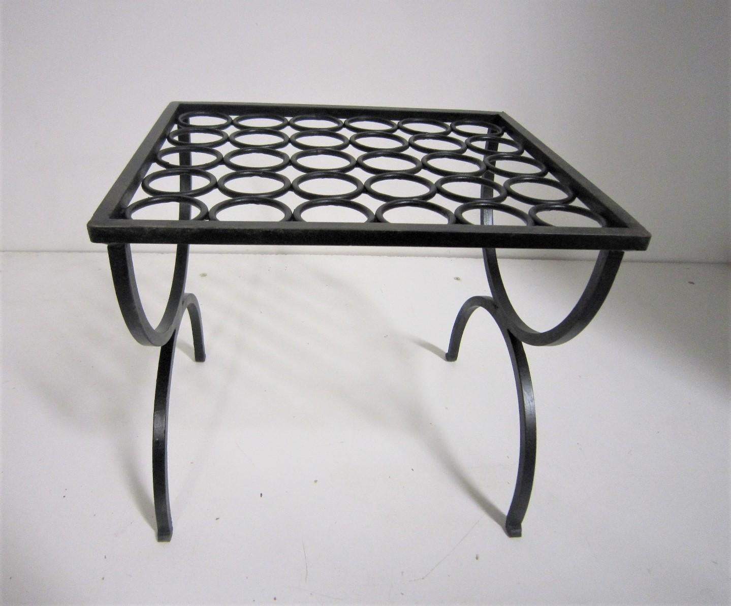 An original period wrought iron foot stool with circular pattern and double 