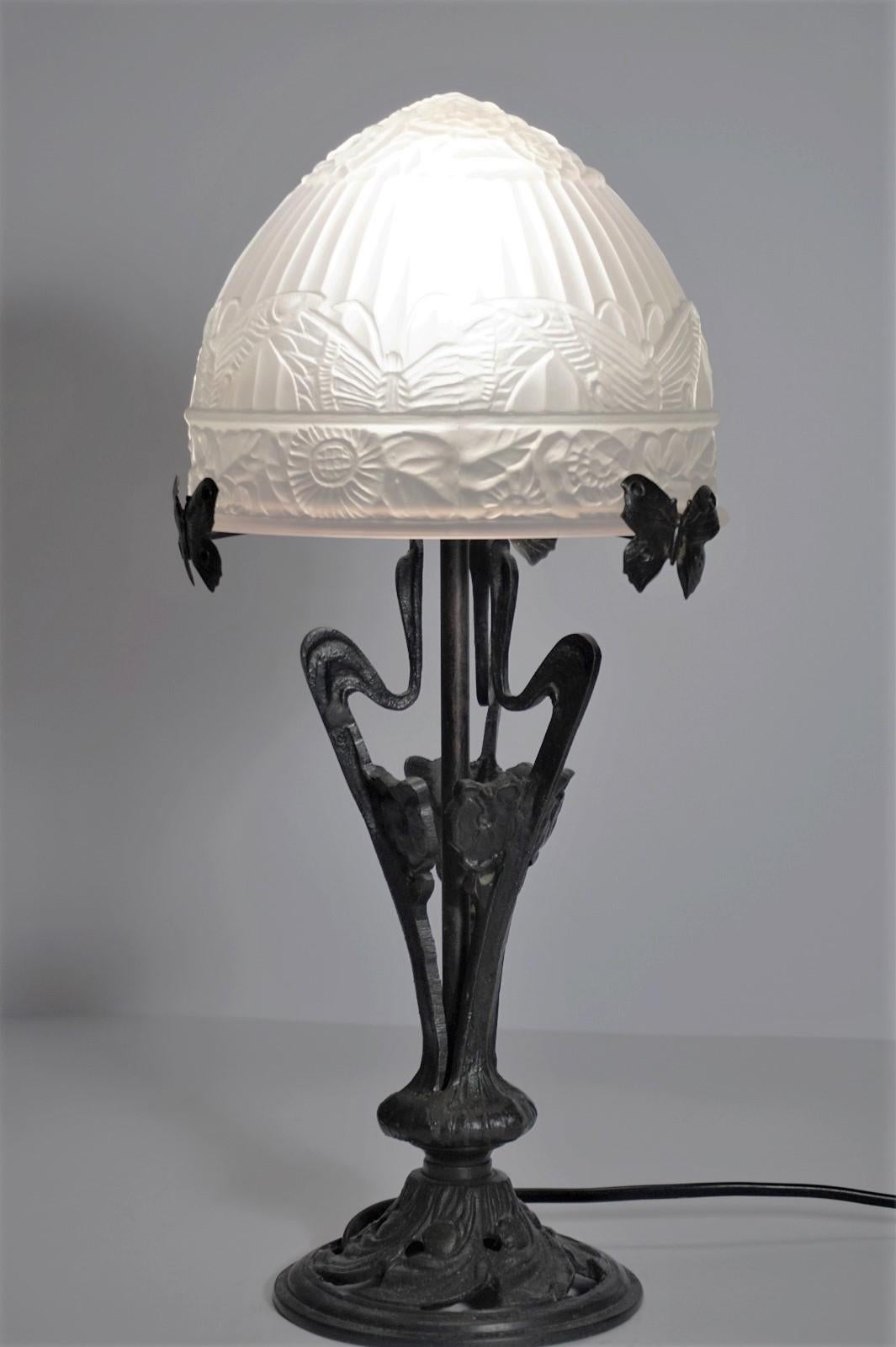 A lovely Art Deco table lamp of wrought iron with black finish with beautiful frosted art glass shade with over flowing floral and butterfly motif, France circa 1930-1939.
It takes one E14 light bulb up to 60W
Measures:
Height 16 in (40.5