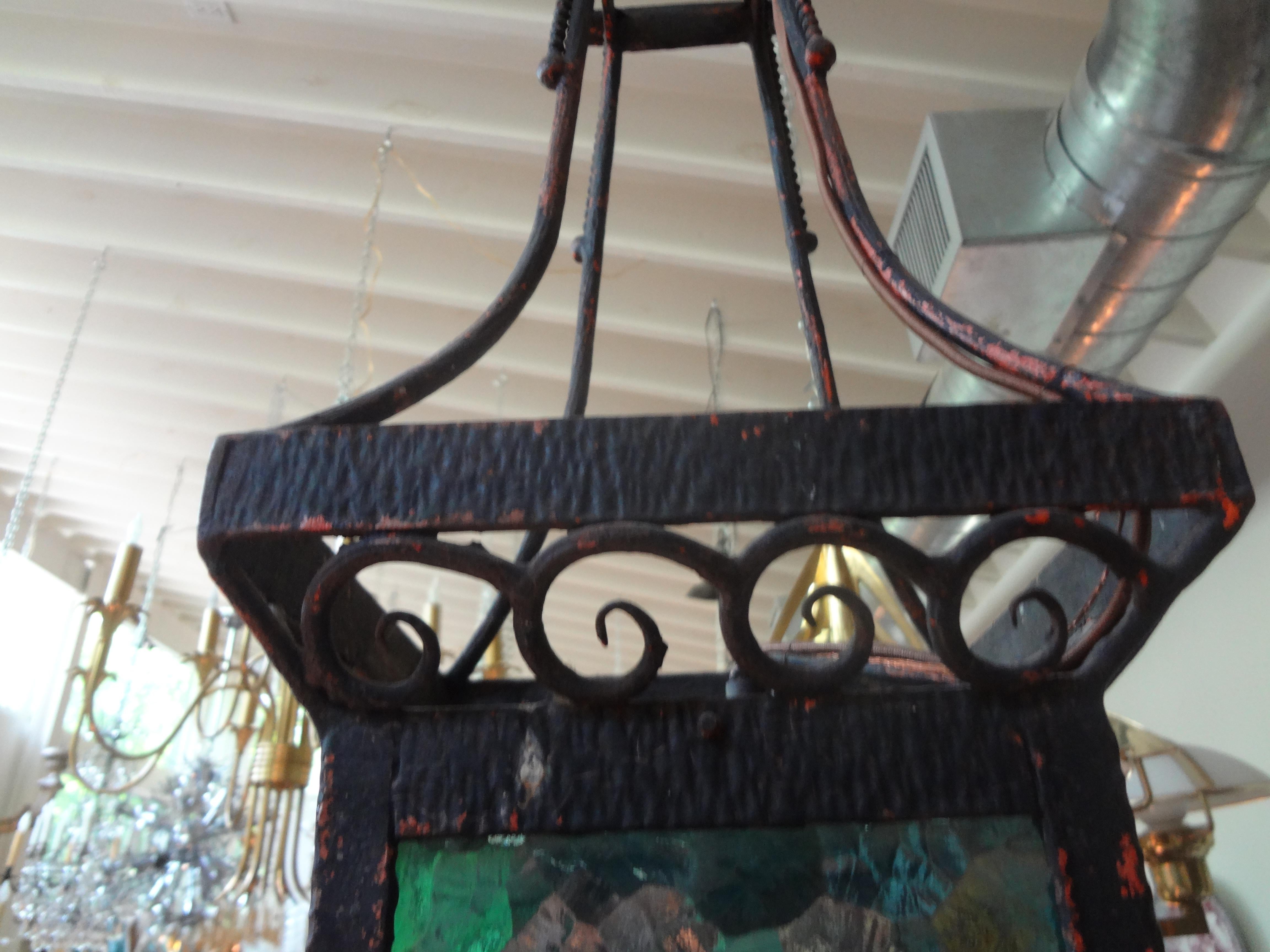 French Art Deco wrought iron lantern.
Great period French Art Deco hand forged wrought iron lantern. This beautiful French lantern has subtle deco accents with lovely multicolored glass panels. The glass panels could easily be changed out to clear