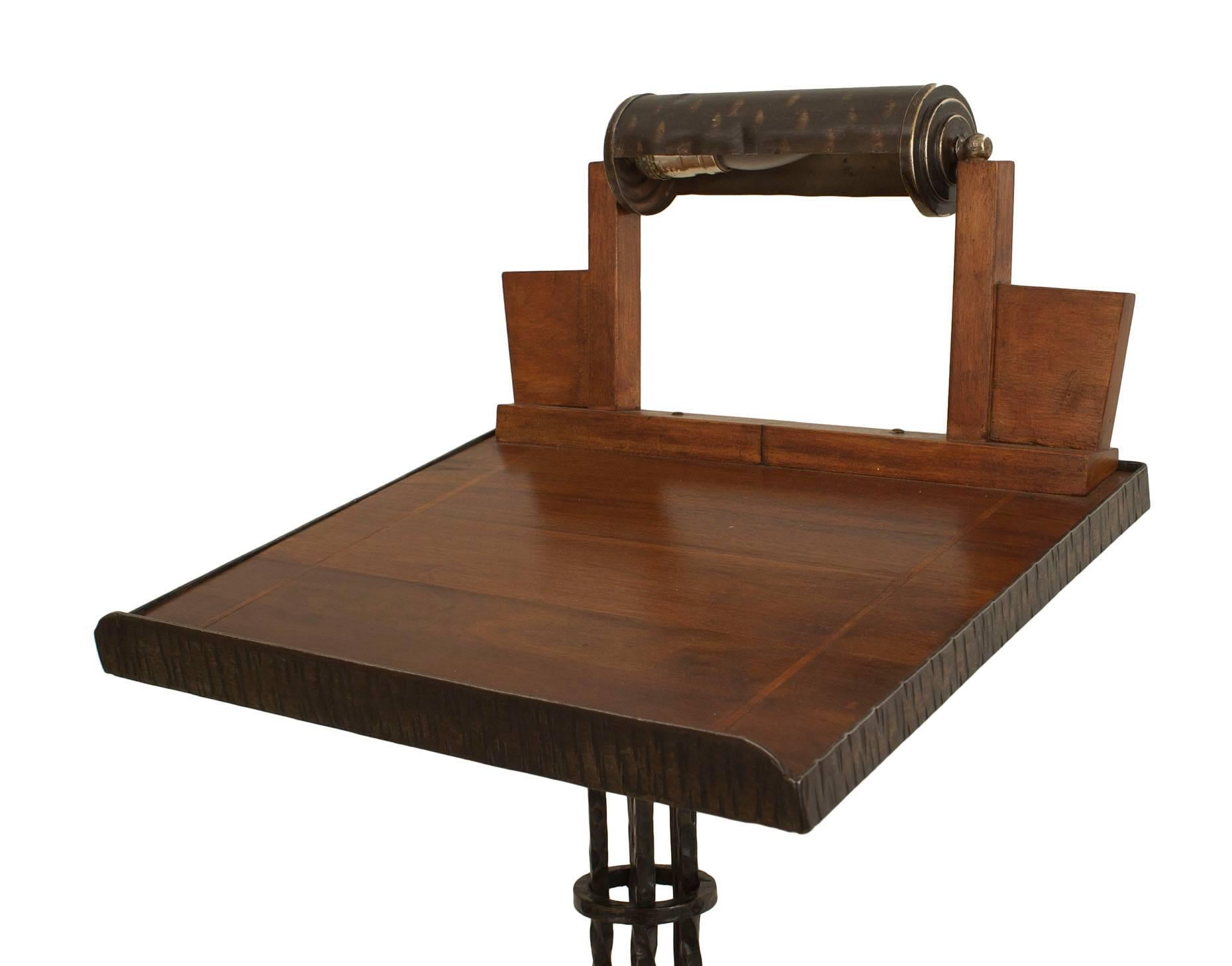 French Art Deco wrought iron lectern with a light above a mahogany slant surface supported by a square open base with applied scroll design.
 