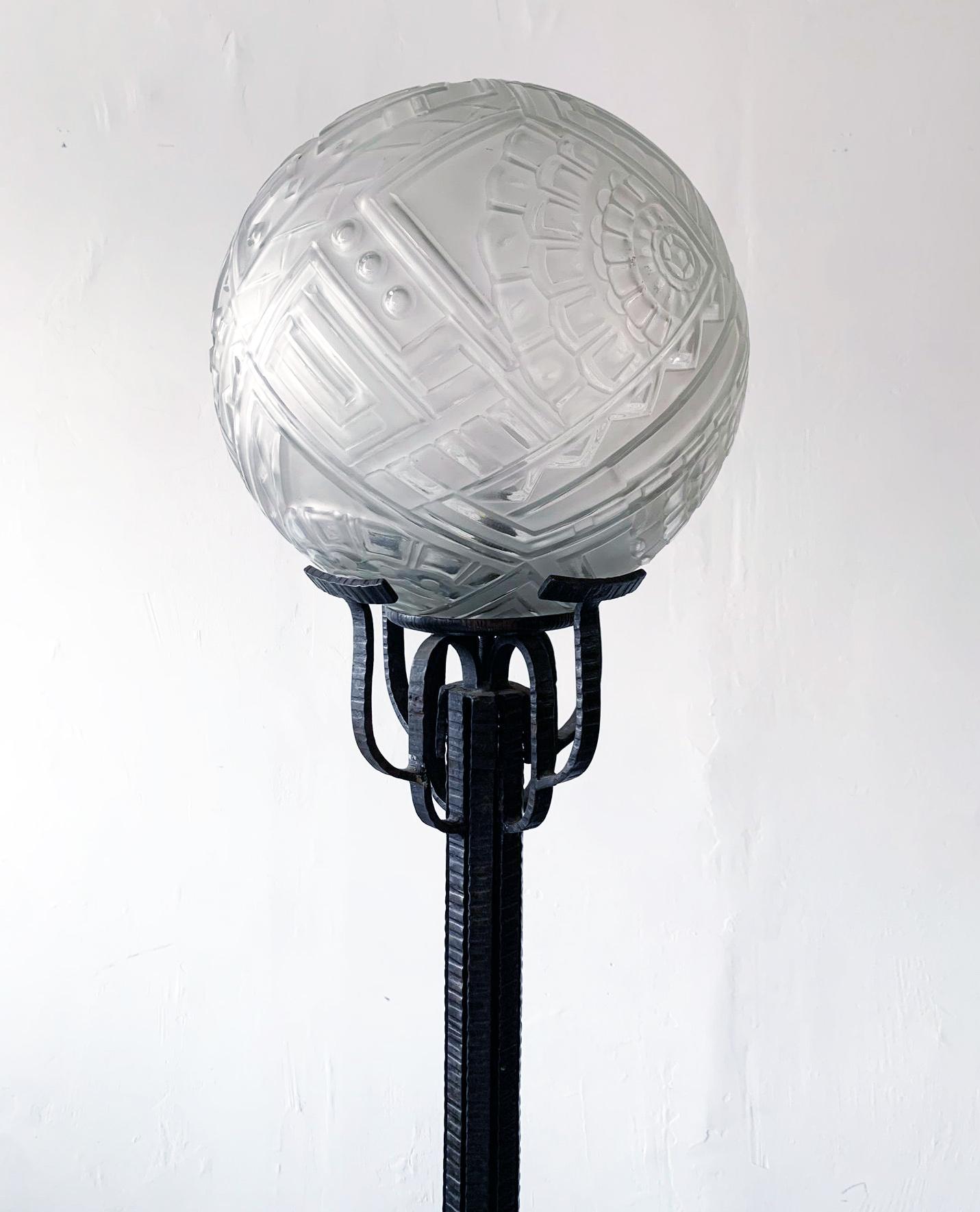 This floor lamp is absolutely stunning! This piece came from an estate with a vineyard in Ojai, CA that was furnished entirely in French art deco pieces. This Edgar Brandt style period floor lamp is in cast wrought iron and features a glass globe /