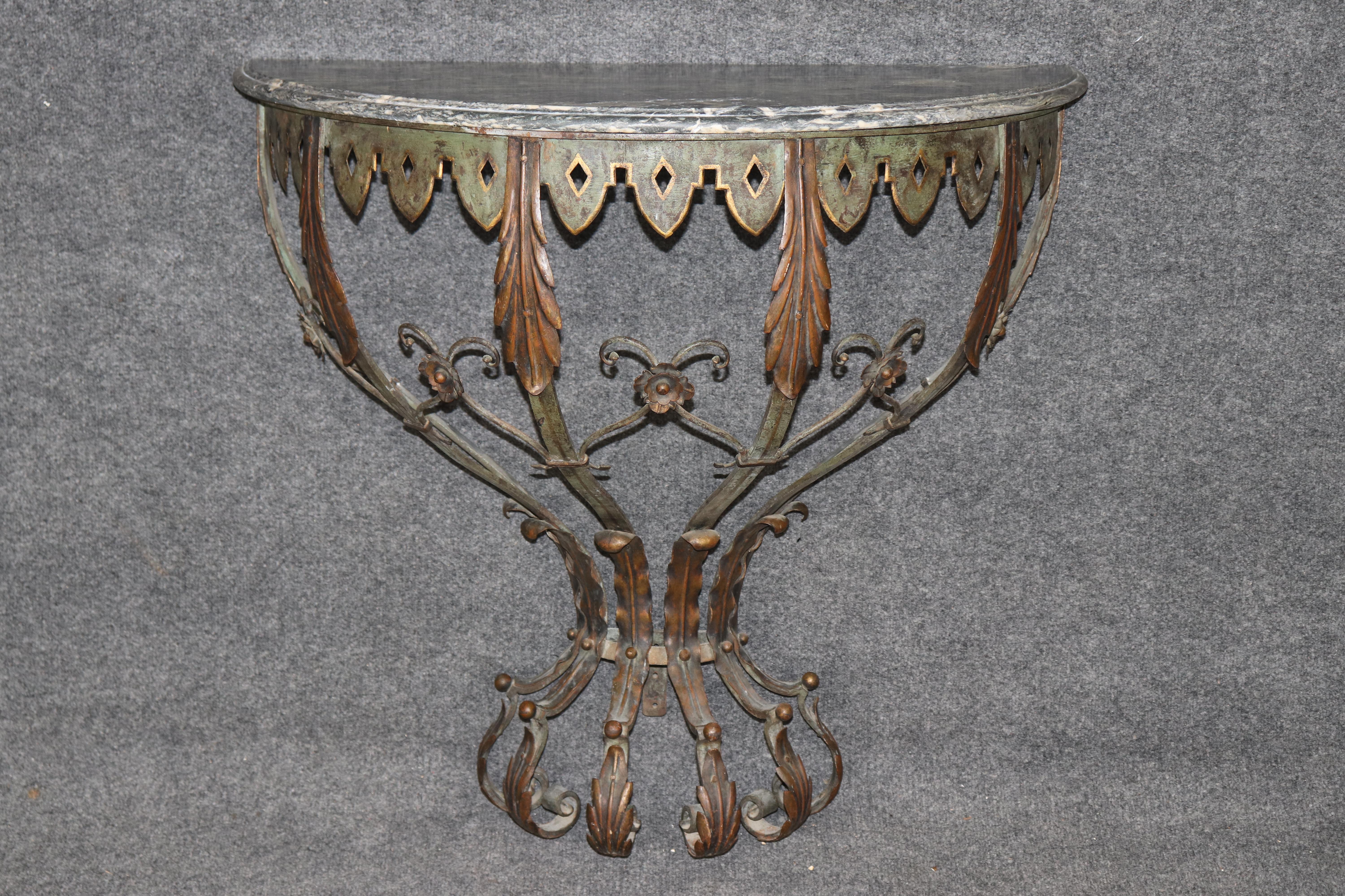 Dimensions - H: 31 3/4 in W: 34 1/2 in D: 17 in 

A timeless expression of form and function, this French Art Deco wrought iron wall-mounted demilune console table, circa 1930s, is a striking example of the elegance and craftsmanship of the Art Deco