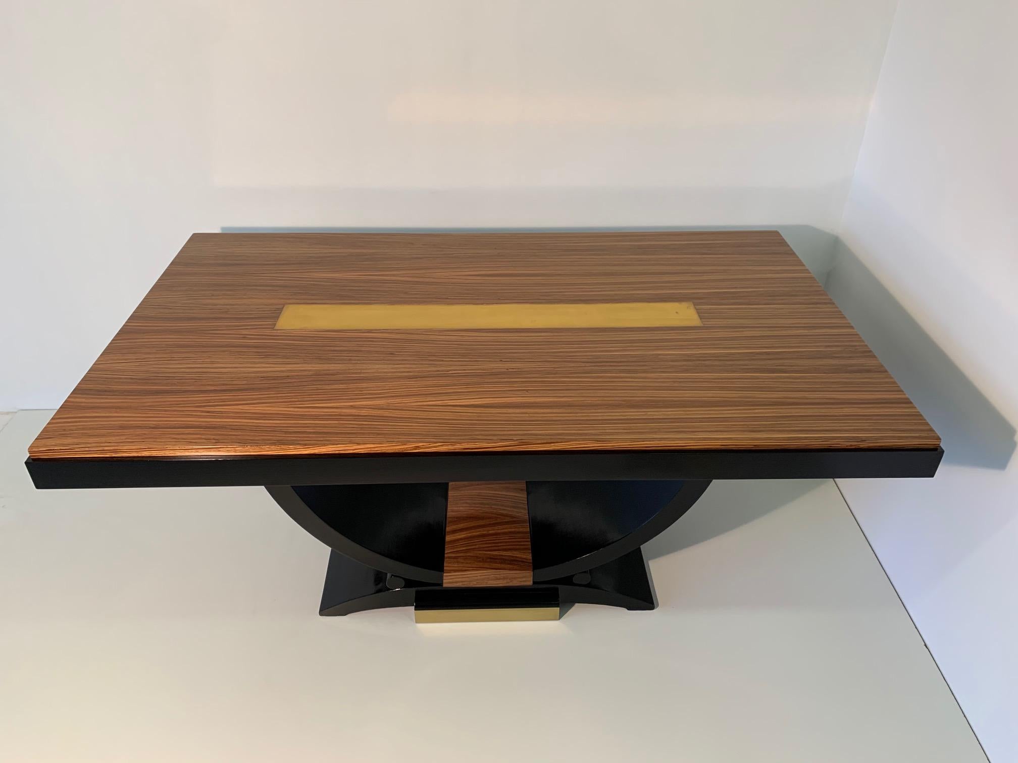 Rare French Art Deco table from the 1930s, the top is covered in zebra wood with a central decoration in brass foil.
The base is black lacquered.
The table is in excellent condition because it has just been restored.