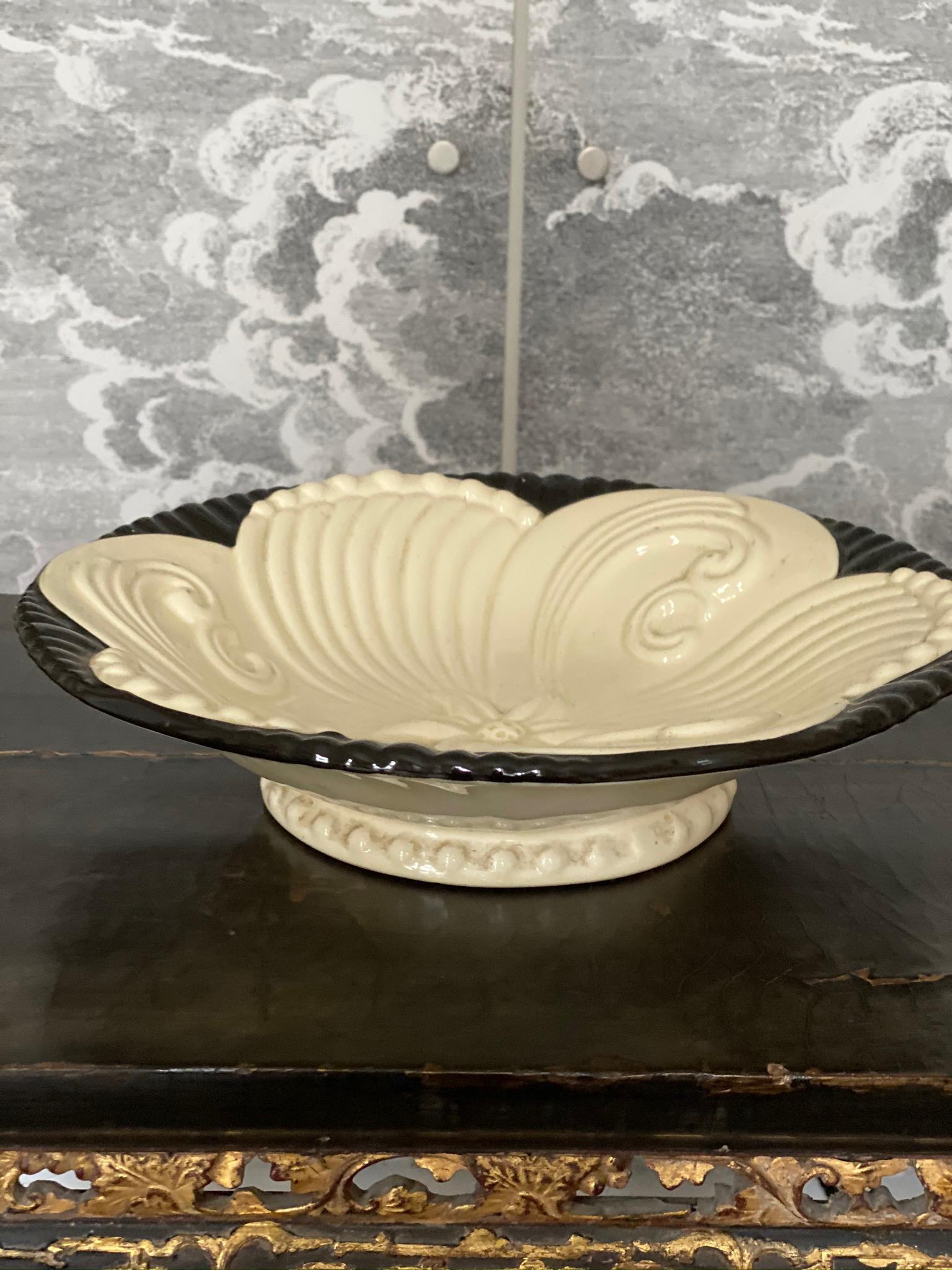 This Art Deco ceramic bowl with foot is from the 1920s. It is round and the floral design is raised and forms a beautiful relief. The black and white glaze accentuates the flower shape and makes the hearts of all Art Deco lovers beat faster.
