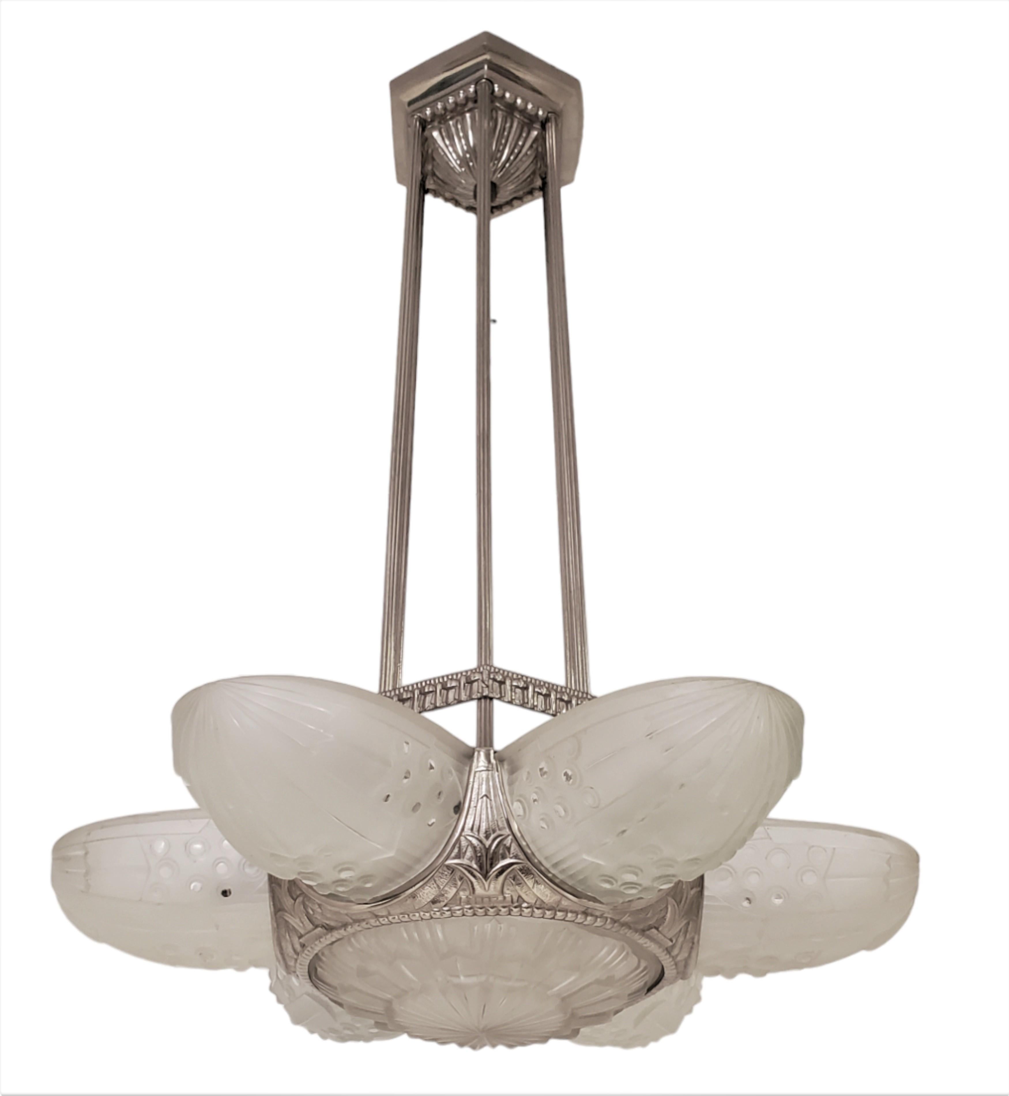 
Sleek and modern looking fine French Art Deco chandelier signed Leleu featuring six frosted art glass panels propelling outward of a central coupe.
The panels feature a starburst or floral blossom overall shape, supported by the original shiny