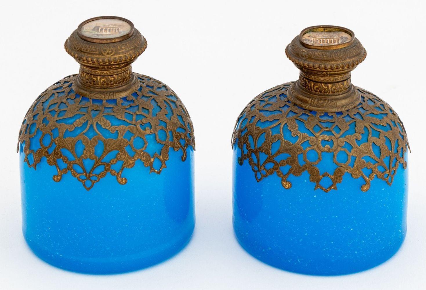 Groupe de trois bouteilles bouchées en verre d'art montées sur laiton, vers 1870, chacune avec des fleurons émaillés représentant des paysages urbains, deux pots en verre bleu paon, un bouchon représentant la Bourse de Paris et l'autre l'Hôtel de