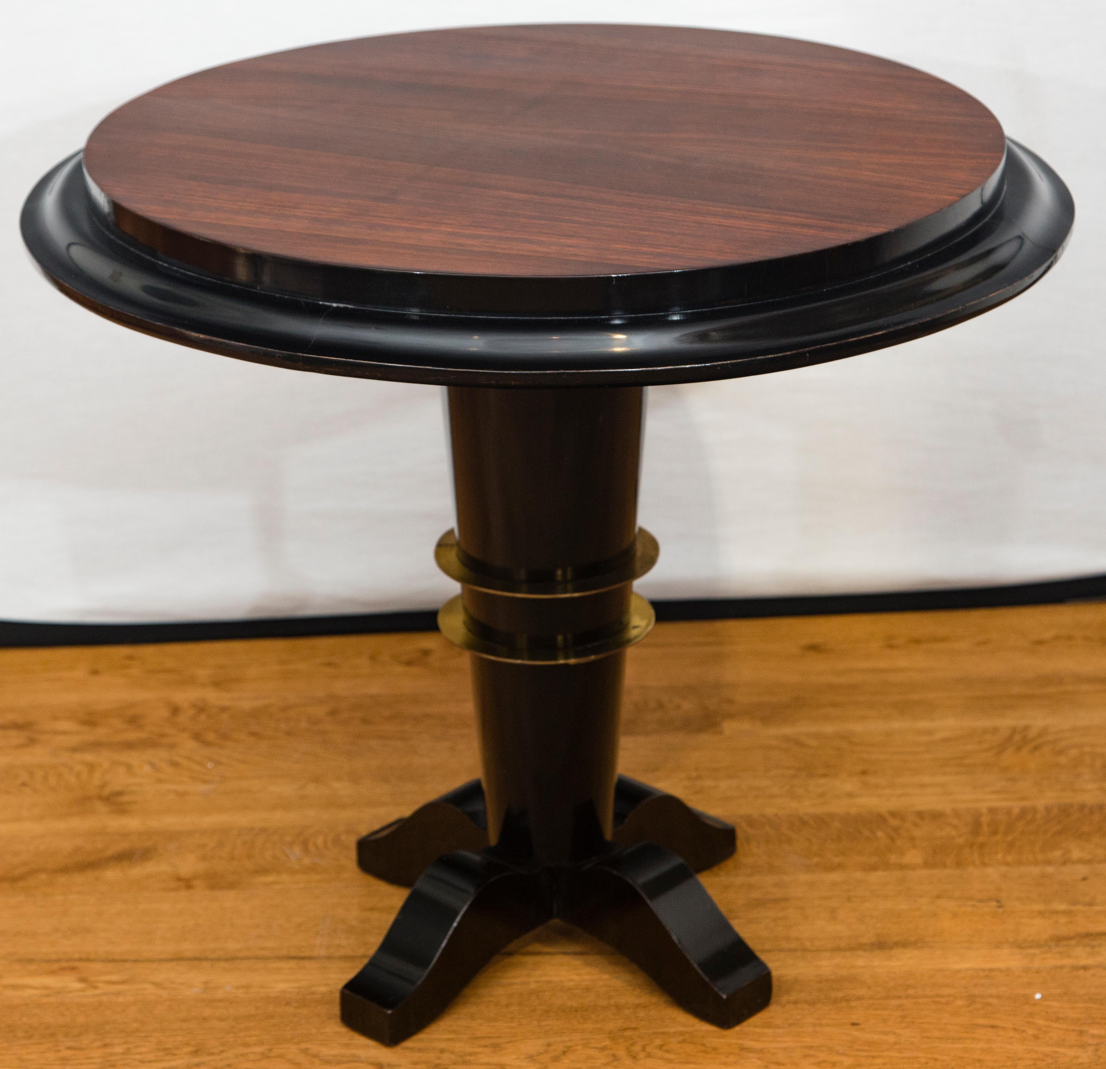 A prominent French Art Deco side table, circular raised plateau in palisander wood and black lacquer moulding rest above a tapered black lacquered column base with brass detailing
Dating: circa 1940
Origin: French
Condition: Excellent