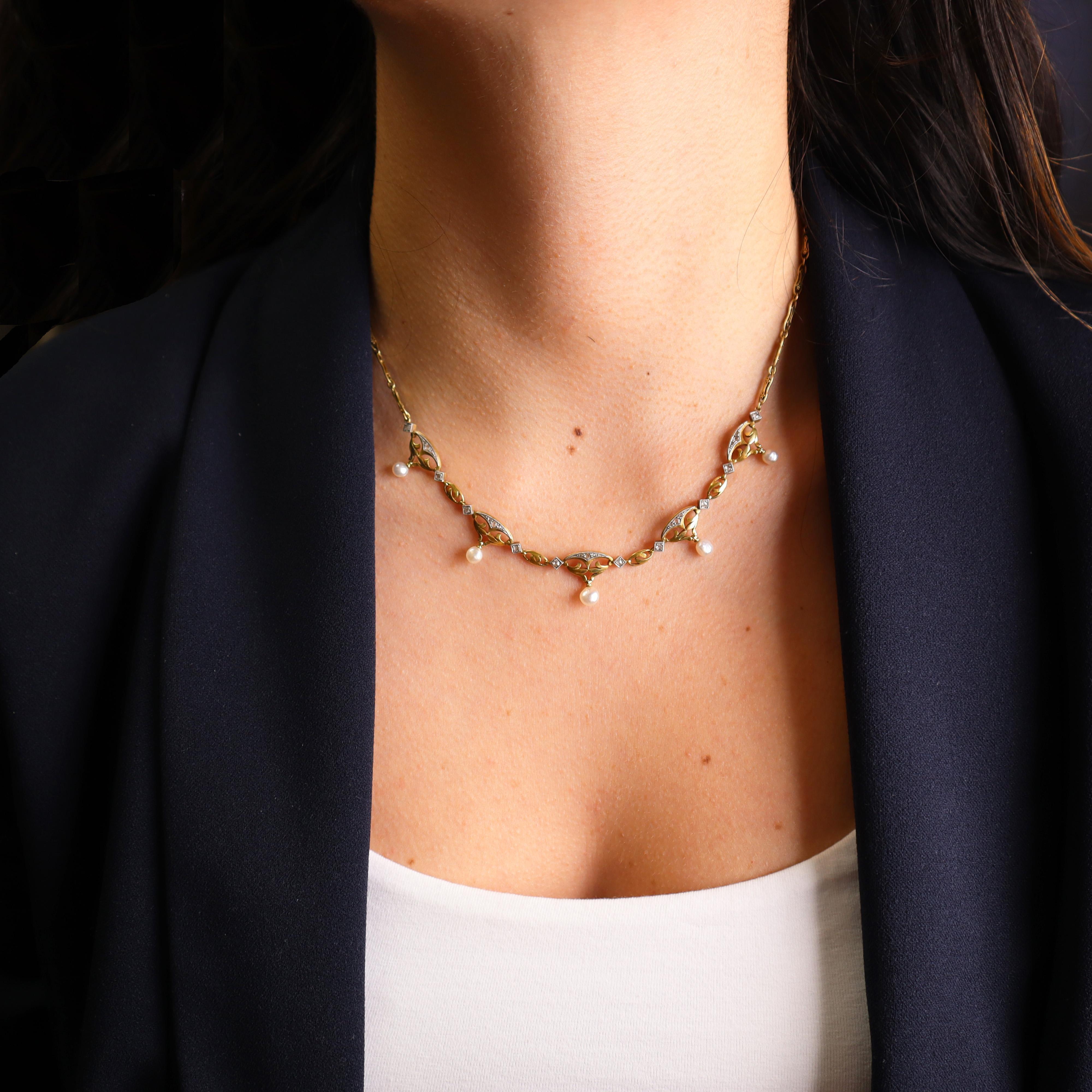 This stunning Art Nouveau necklace, dating from the 1890–1900s, is beautifully crafted in 18k yellow gold and platinum, adorned with intricate millgrain patterns that exemplify the era’s refined artistry. Five baroque natural pearls are elegantly