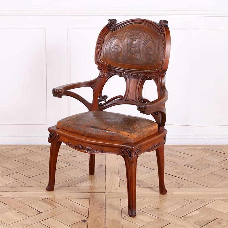 This exquisite Art Nouveau armchair from Paris exemplifies the elegance of French turn of the century design. Constructed from solid Mahogany that has developed a rich patina, the chair features masterfully hand-carved  flowing lines and intricate