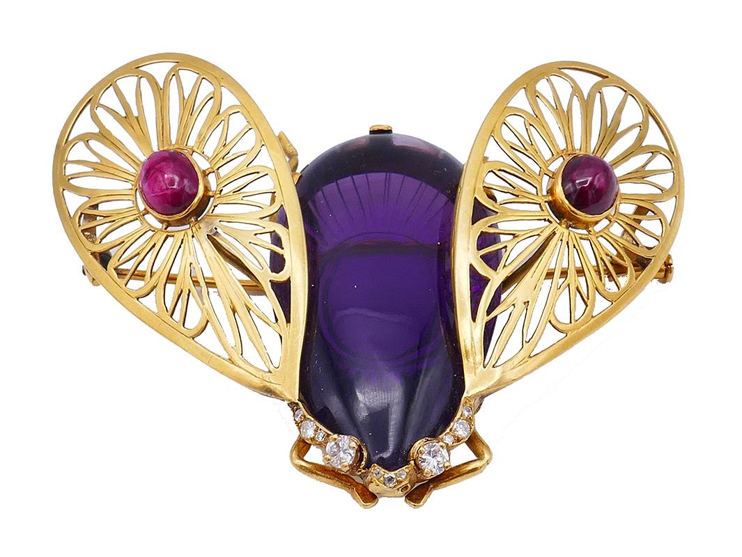	A French Art Nouveau Bee pin brooch clip made in 18 karat gold and featuring colored gemstones and diamond. This piece is one of the purest examples of Art Nouveau flights of fancy.
	The sinuous lines of the glossy amethyst body are captivating.