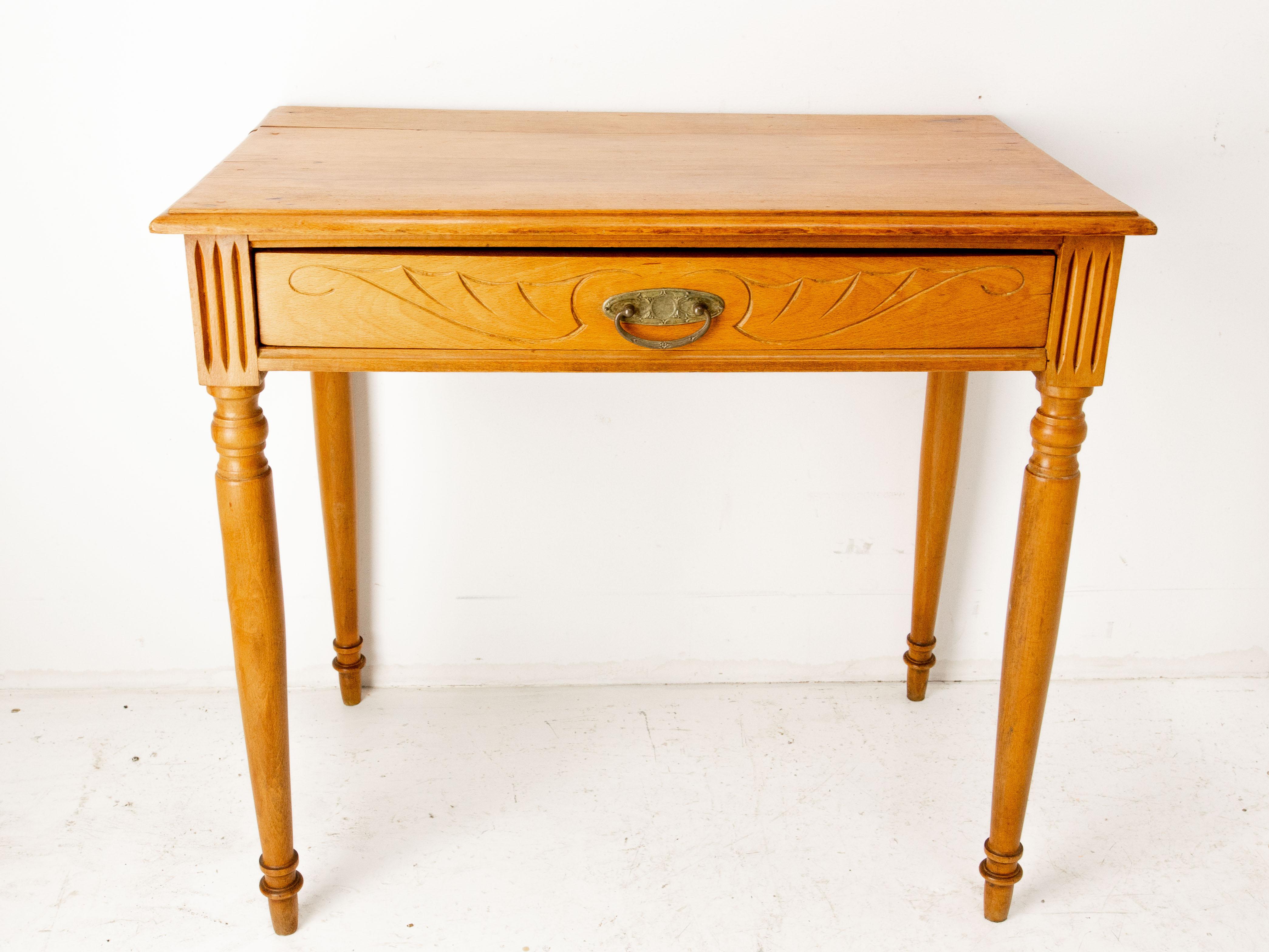 French writing table, little desk or side table, circa 1900.
Made in the art Nouveau period : the carving of the drawer and its handle is typical of the lines of this artistic movement. 
The beech has been tinted in a cherry-wood color, brass